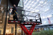 High-rise window cleaner Alex James from Columbia Building Services washes the interior windows of Crystal Court inside IDS Center in Minneapolis, Min