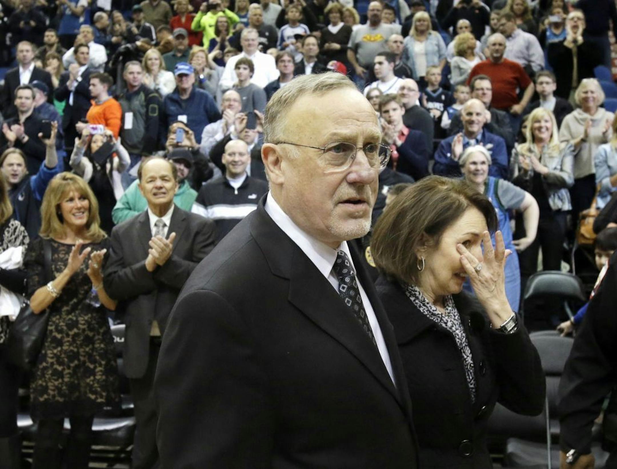 May Kay Adelman wipes a tear as she accompanies her husband, Timberwolves head coach Rick Adelman, after the team defeated the Pistons for his 1,000th career win