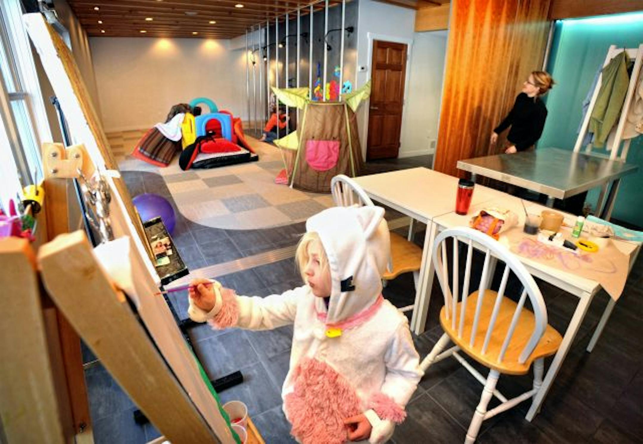 Nora Yocum worked on an art project while brother Oliver constructed a marble obstacle course on the magnetic wall. Kirsten Yocum stood next to the wood doors that can slide to separate the two rooms if needed.