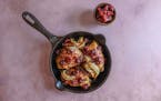 A savory skillet dish featuring chicken and vegetables on a pink background, complemented by the flavors of cherry jam and dijon mustard.