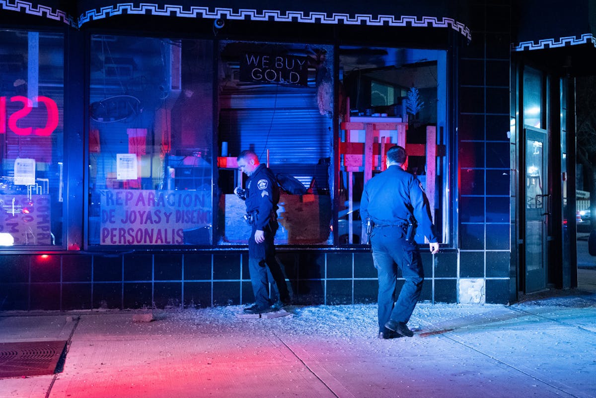 Minneapolis police officers check a damaged building on Lake Street.