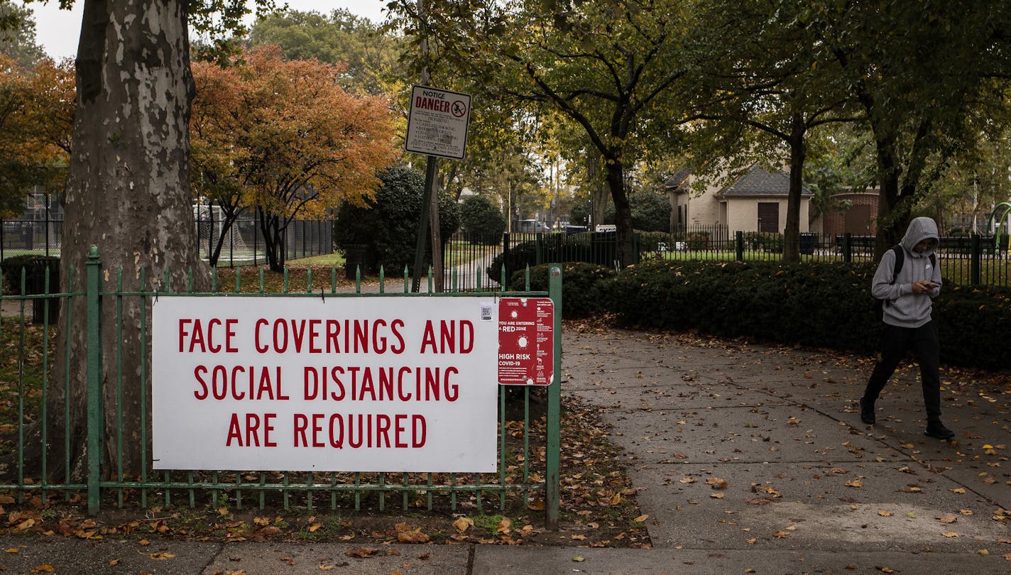 A notice about face mask and social distancing requirements at Independence Park in Newark, N.J., Oct. 26, 2020. At least 672 Newark residents have died since March after contracting the coronavirus. (Bryan Anselm/The New York Times)