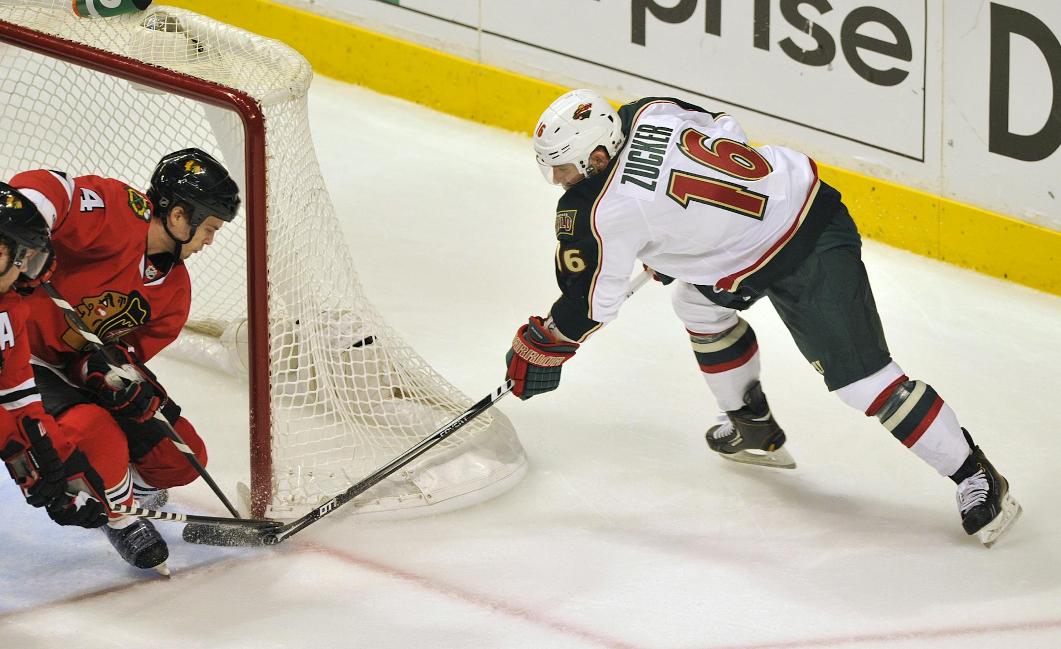 Chicago Blackhawks' Niklas Hjalmarsson left, blocks the wraparound shot of Minnesota Wild's Jason Zucker