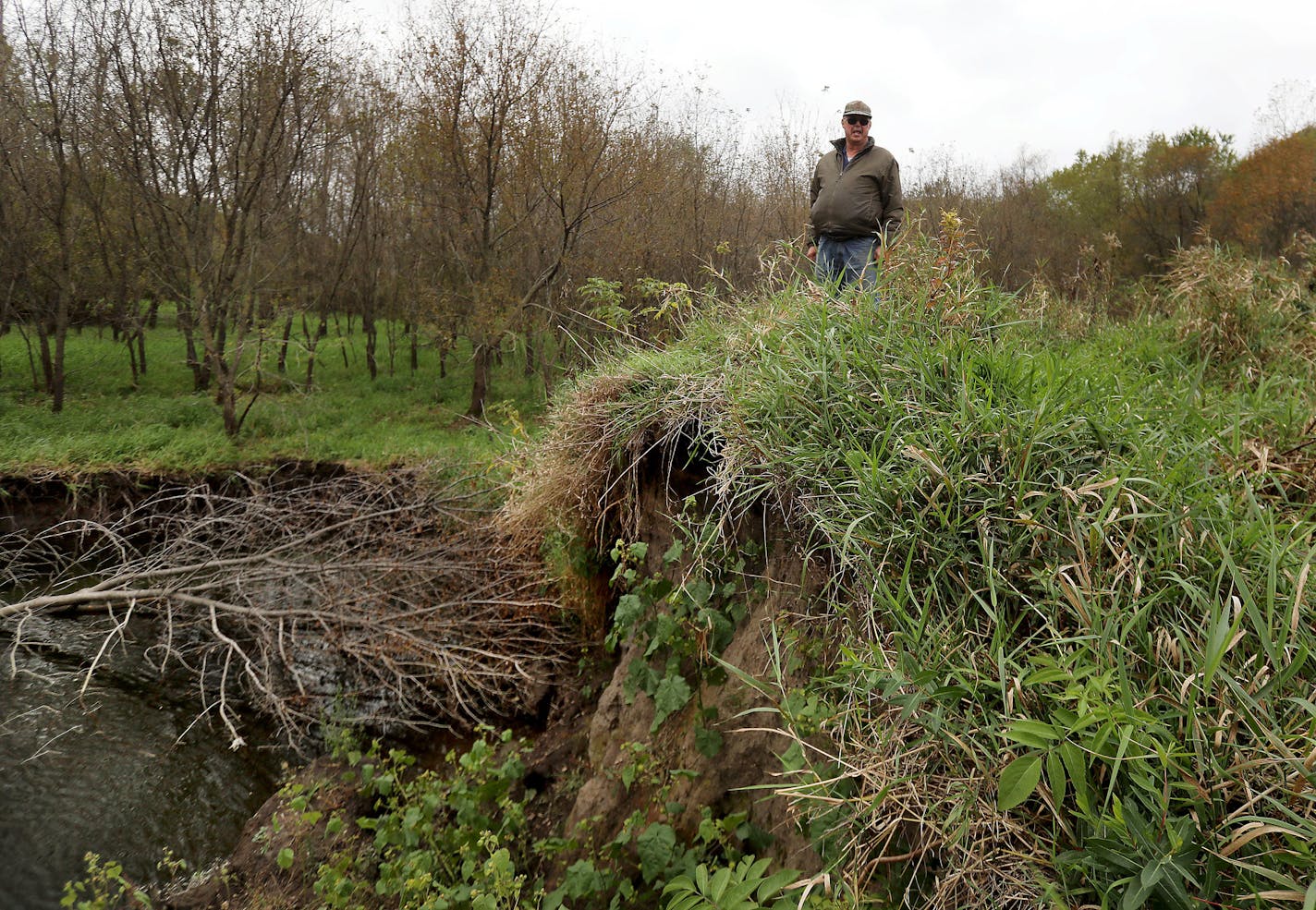 Landowner Albert Carlson stands atop a blown out earthen dike where this spring the nearby flood-swollen Zumbro River busted an 80 foot-long hole in the dike, flooding his 120 acres of farm land near Theilman, Minnesota. Previously, the pond that now exists was all a continuous earthen-dike, preventing flood waters from spilling into his farm land, which he rents out.