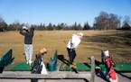 Cash Frable, left, and William DeVries hit some balls onto a snowless driving range in January at the Francis A. Gross Golf Club in Minneapolis.