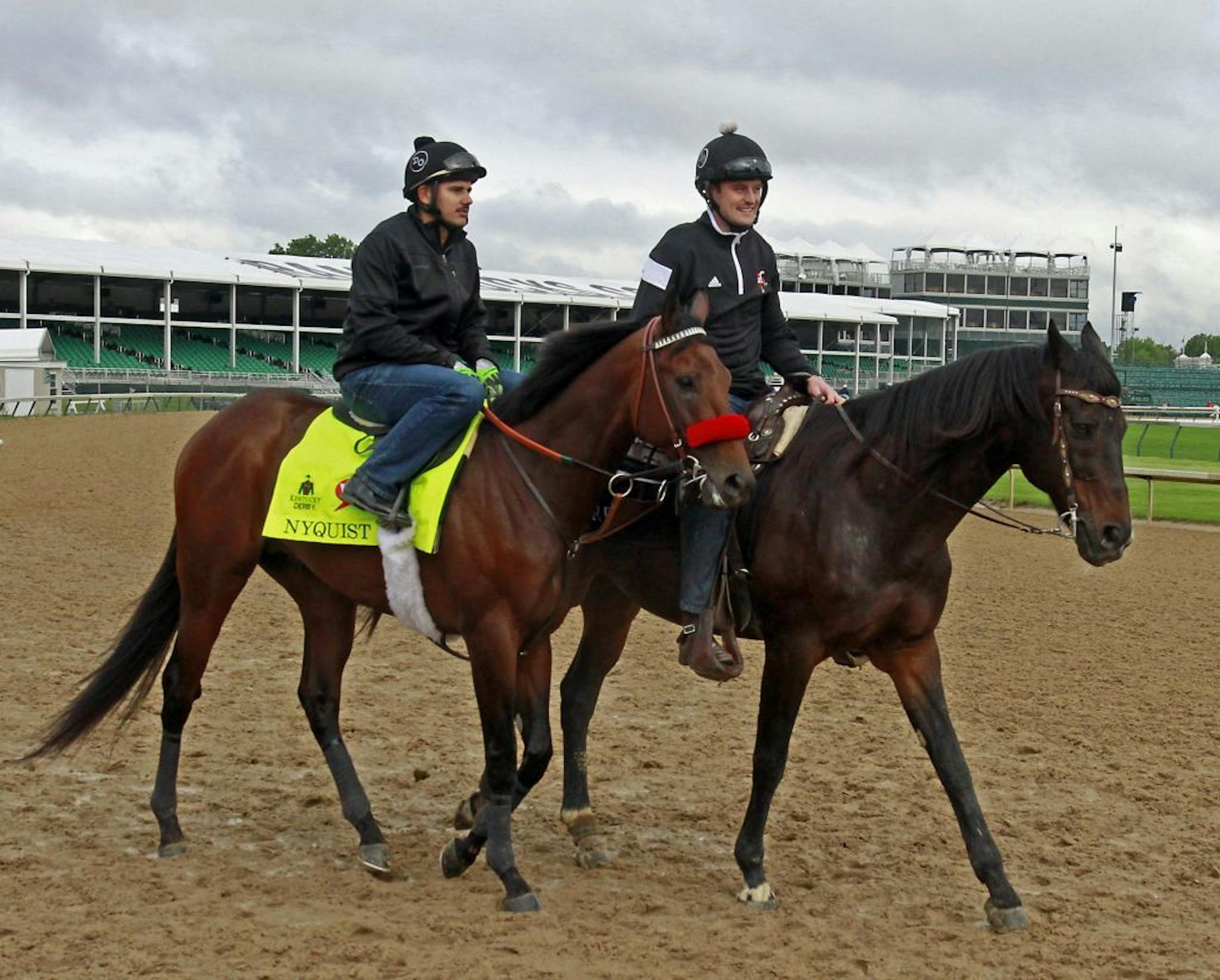 Kentucky Derby favorite Nyquist, left, with exercise rider Jonny Garcia aboard, walks out on the track led by assistant trainer Jack Sisterson at Churchill Downs in Louisville, Ky.,