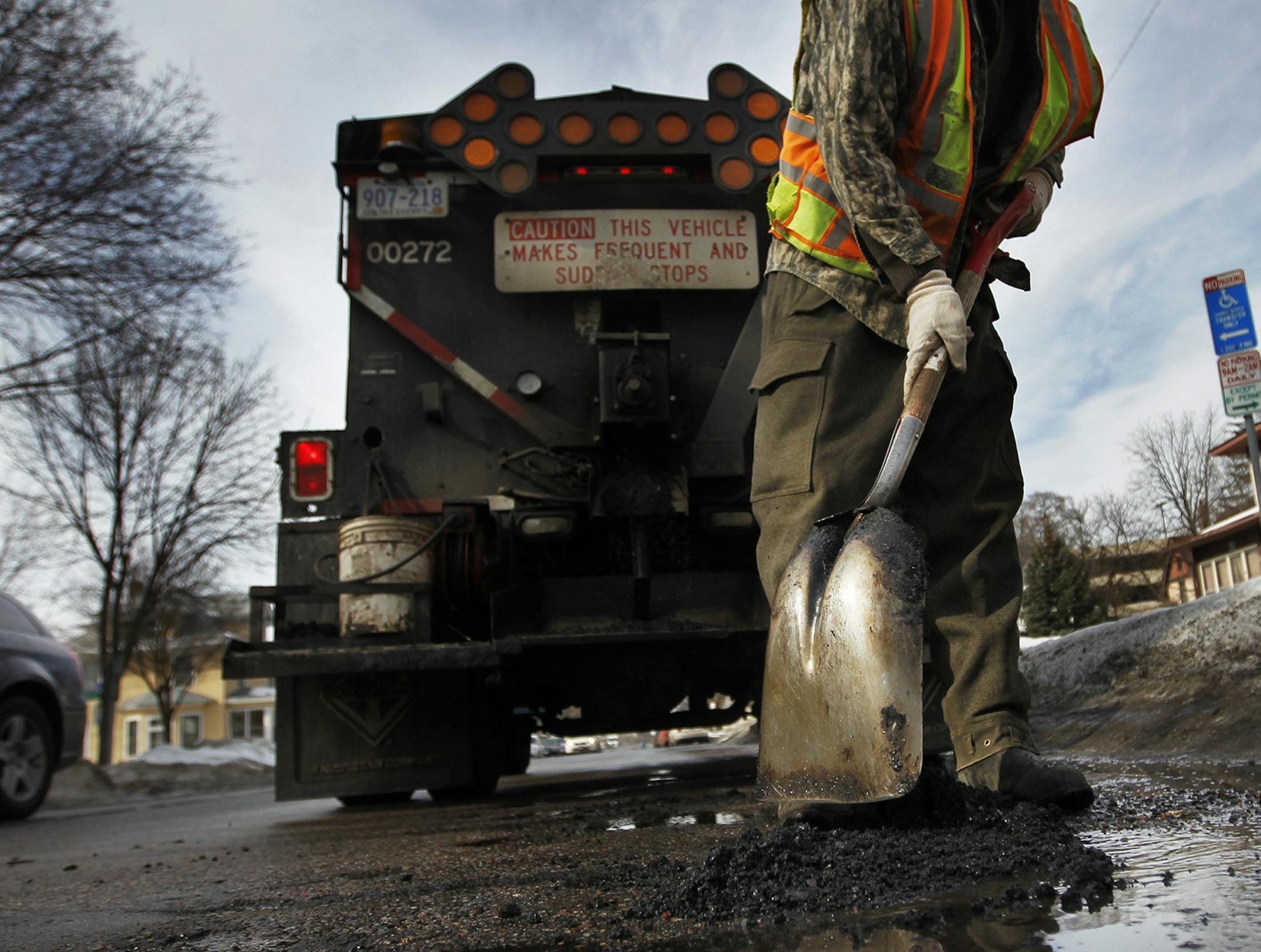 BoRichard TsongTaatarii/rtsongtaatarii@startribune.com Minneapolis, MN;02/16/11;left to right ] City of Minneaplis public works worker Bob Koch applied a "cold patch" of asphalt to fill in a hole 31st Av in Uptown. He said it was a temporary fix. The patch seals itself as cars roll over it. ORG XMIT: MIN2014032414542751