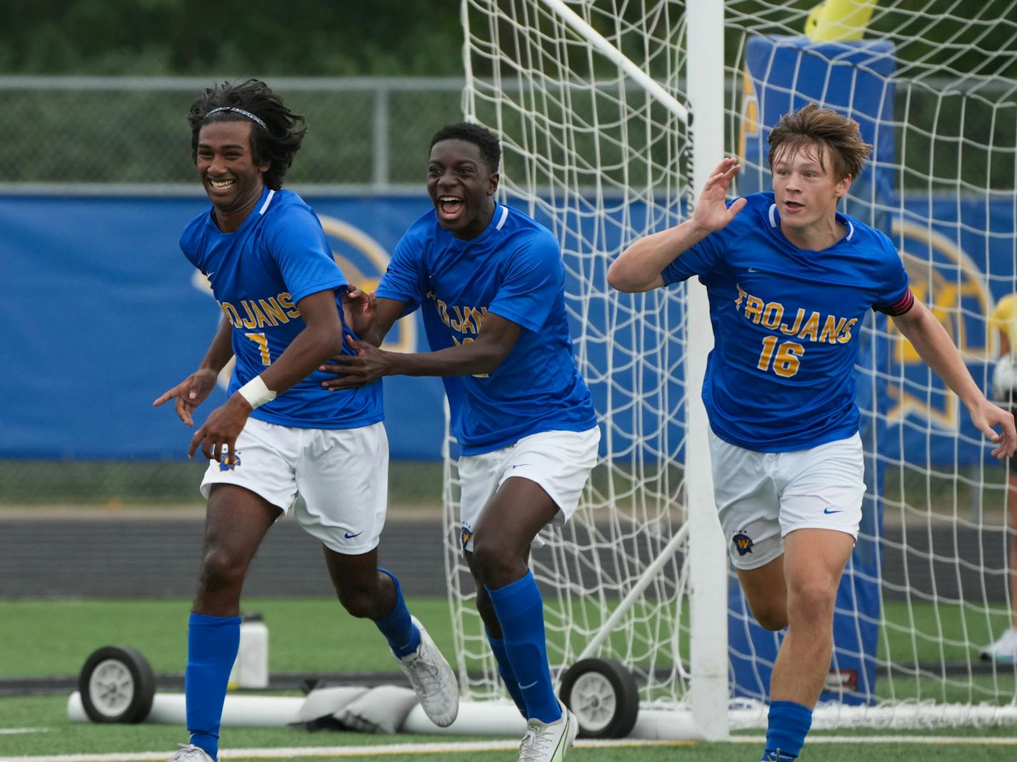 Trojans Eddy Ignatius (7), Aaron Kibaya (22), and Charlie Piler (16) celebrate after Ignatius scored against Washburn in the first half at Wayzata High School in Plymouth, Minn., on Saturday, Sept. 9, 2023. Wayzata defeated Washburn 5-1.