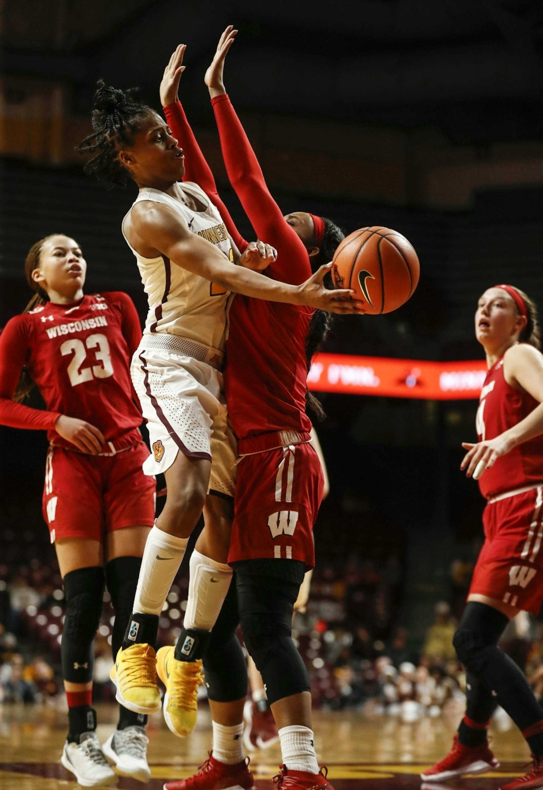 Minnesota Golden Gophers guard Kenisha Bell (23) pass the ball around Wisconsin Badgers Marsha Howard (11) in the first half.
