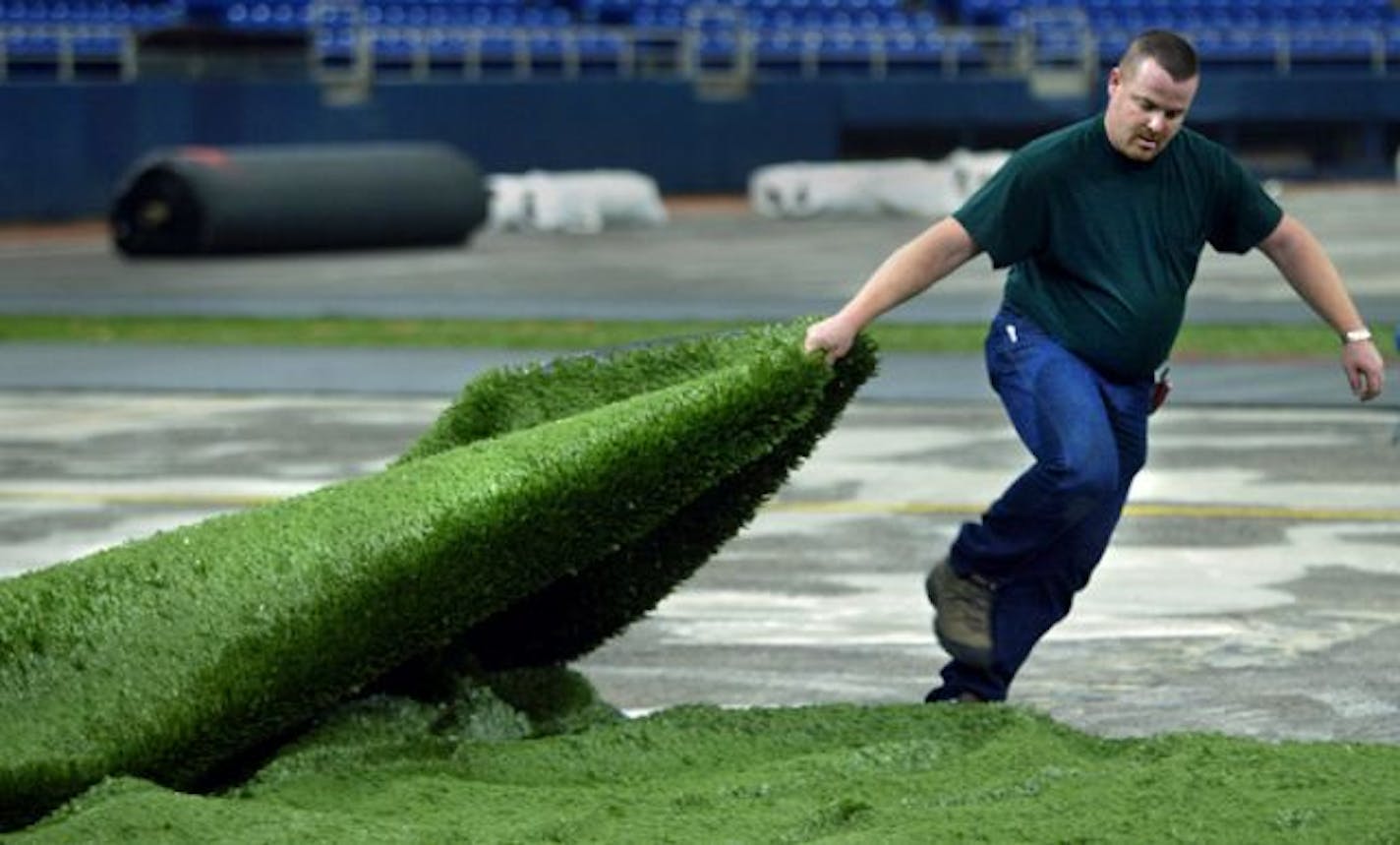 Minneapolis, MN., Tueaday, 1/16/2004. Jim O'Donnell, member of the Midwest Field Turf and Quest Field Turf Crew pulled the first of 120,000 square foot of "Field Turf" into position at the Metrodome. The new field turf will take ten to fourteen days to install at the dome.