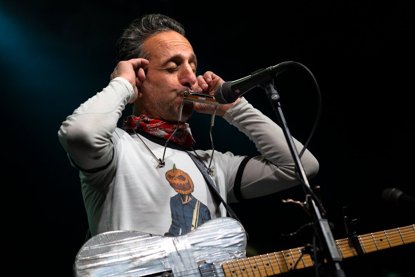 Ike Reilly listens in his earplugs to the sound of his harmonica with First Avenue's brand new sound system during soundcheck before his band's 20th annual Thanksgiving eve show in Minneapolis, Minn. on Wednesday, Nov. 22, 2023. This is the venue's first sound system overhaul in over a decade and the Ike Reilly Assassination will be the first to perform with them. ] Angelina Katsanis • angelina.katsanis@startribune.com