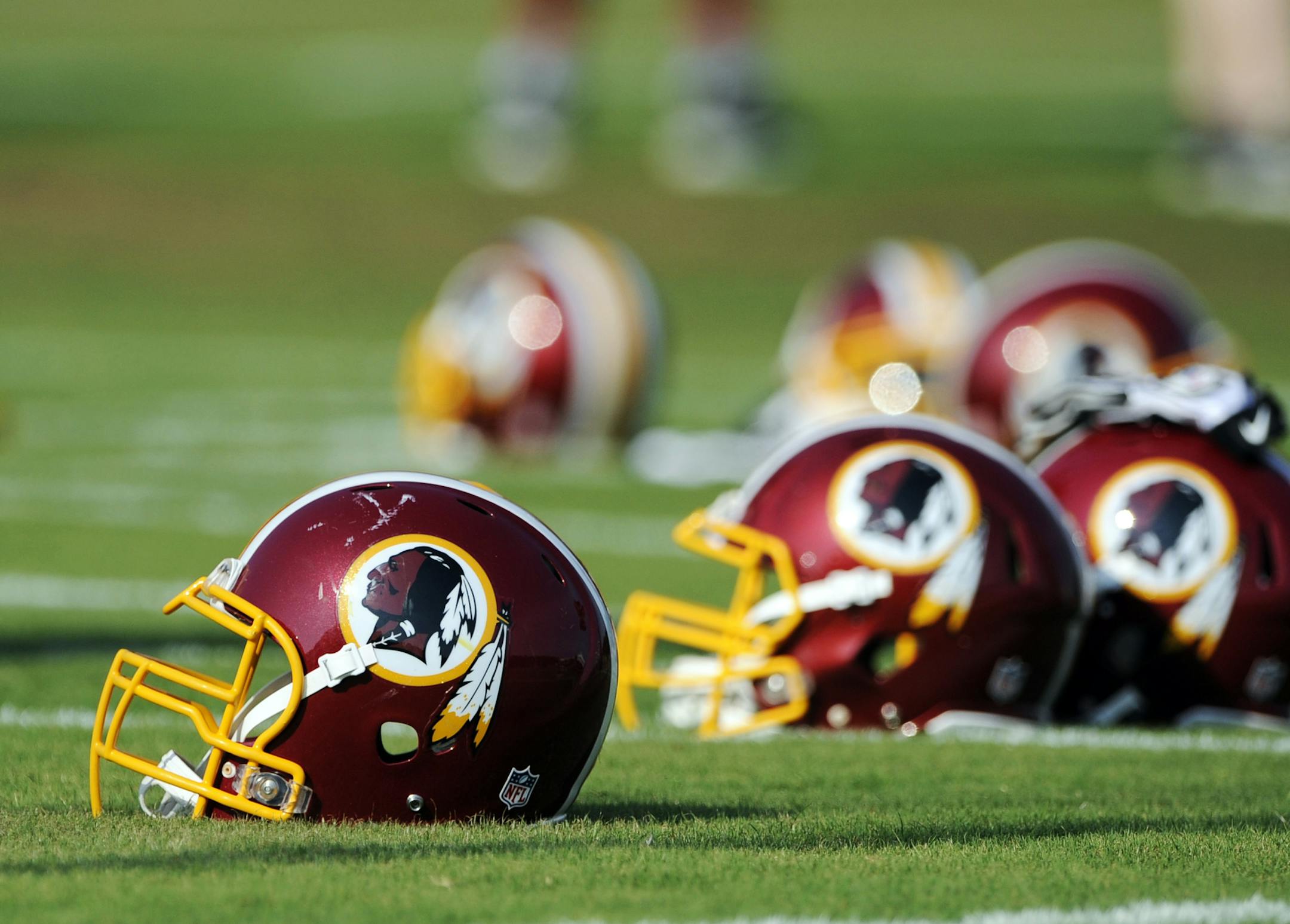 FILE - In this June 17, 2014, file photo, Washington Redskins helmets sit on the field during an NFL football minicamp in Ashburn, Va. The U.S. Patent Office ruled Wednesday, June 18, 2014, that the Washington Redskins nickname is "disparaging of Native Americans" and that the team's federal trademarks for the name must be canceled. The ruling comes after a campaign to change the name has gained momentum over the past year. (AP Photo/Nick Wass, File)