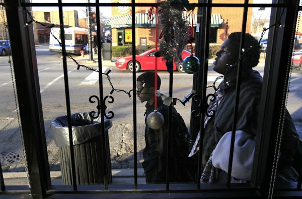 Dec. 3, 2012 photo: Two boys walk past Christmas decorations in the barred window of a business along 79th Street in the Auburn-Gresham neighborhood o