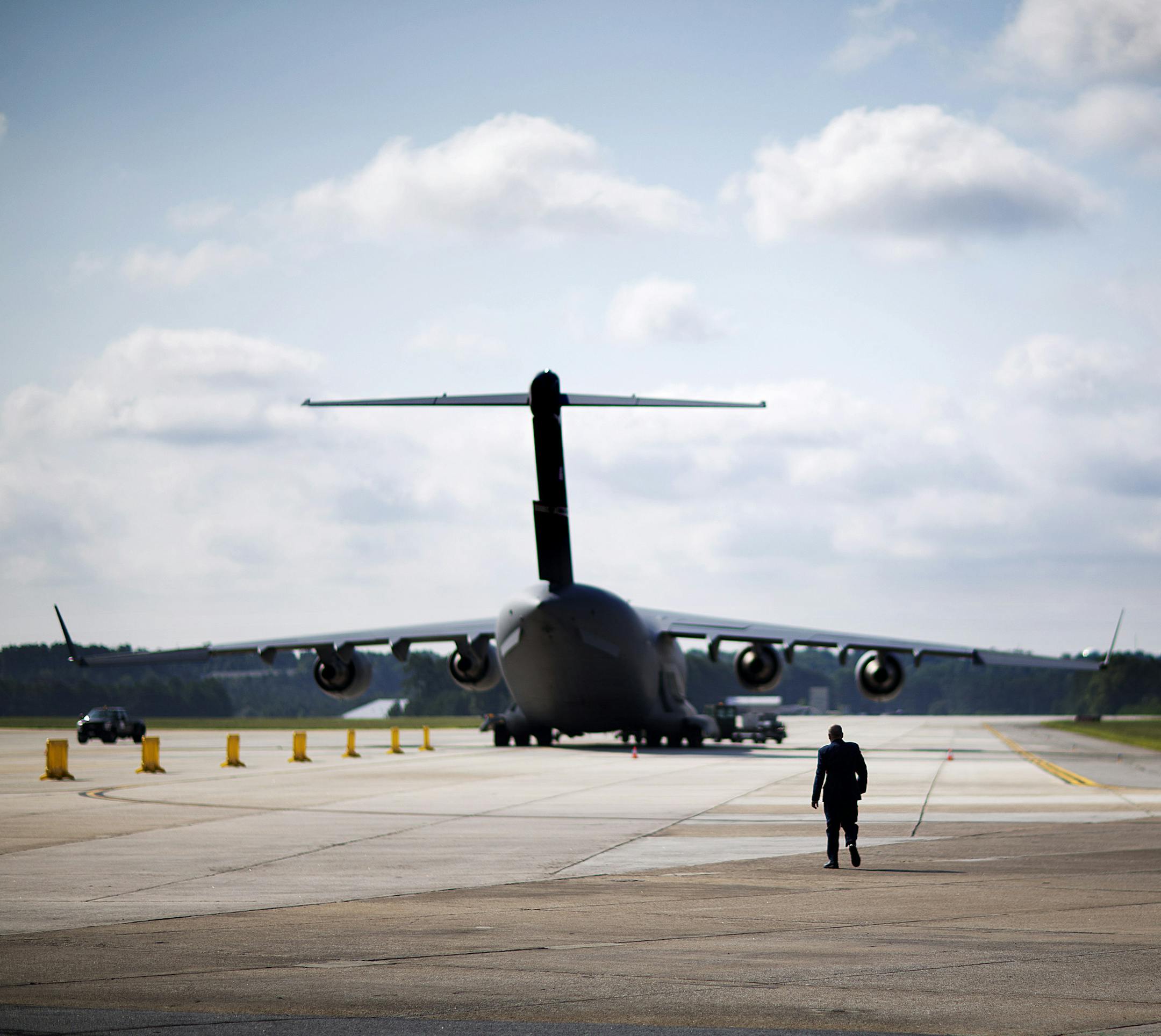 CORRECTS TO C-17 FROM B-17 - An Air Force military member walks out to medevac biocontainment unit aboard a C-17 military transport plane at Dobbins Air Force Reserve Base during a media tour, Tuesday, Aug. 11, 2015, in Marietta, Ga. The State Department and partners unveiled the new public-private containerized biocontainment system for highly contagious pathogens Tuesday. (AP Photo/David Goldman)