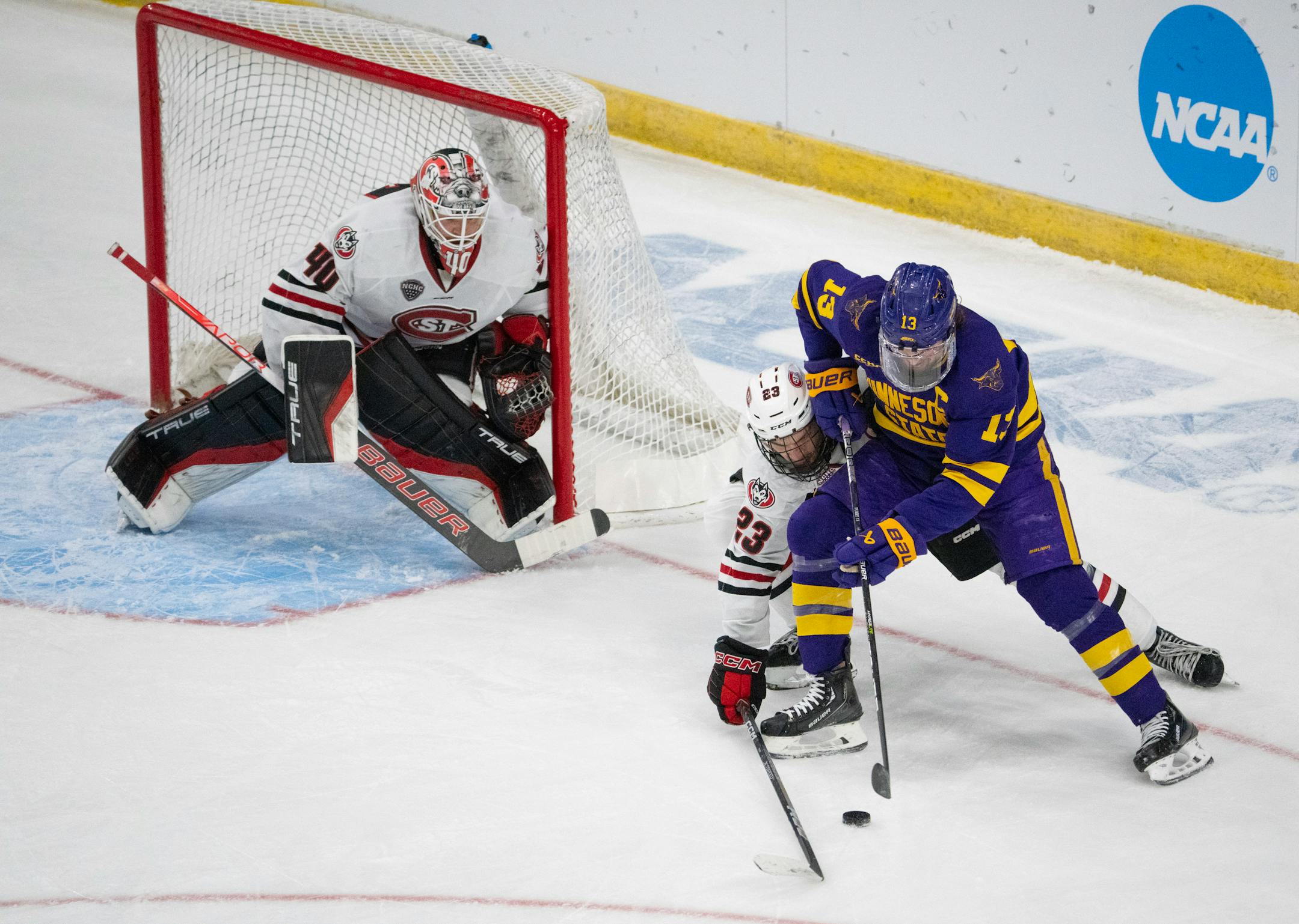 St. Cloud State Huskies defenseman Jack Peart (23) hassled Minnesota State Mavericks forward Brendan Furry (13) as he moved the puck in front of St. Cloud State Huskies goaltender Jaxon Castor (40) in the first period.