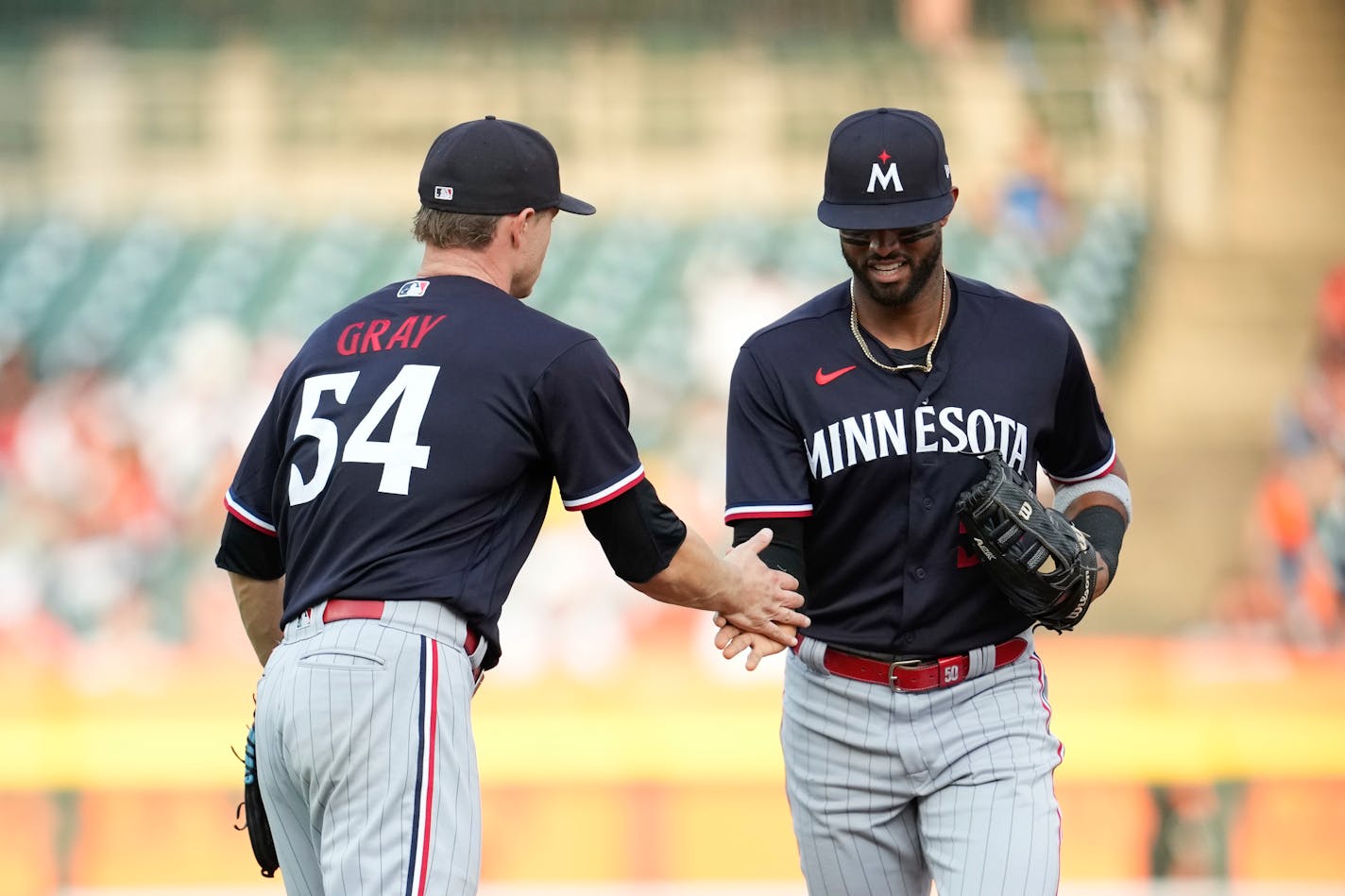 Minnesota Twins pitcher Sonny Gray (54) congratulates left fielder Willi Castro (50) on his catch of a Detroit Tigers' Spencer Torkelson fly ball in the third inning of a baseball game, Tuesday, Aug. 8, 2023, in Detroit. (AP Photo/Paul Sancya)