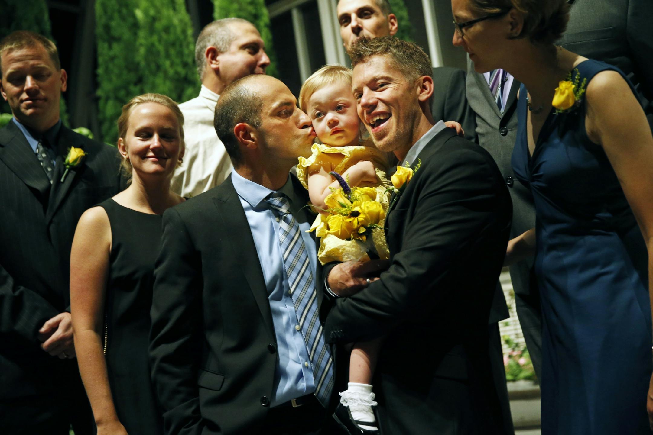 In the Sunken Gardens at the Como Zoo Park Zoo and Conservatory, St. Paul, Minn., family pictures are taken for grooms Reid Bordson, right, and Paul Nolle, left, who will get married with daughter Anna center after midnight when gay marriages became legal in the state of Minnesota .