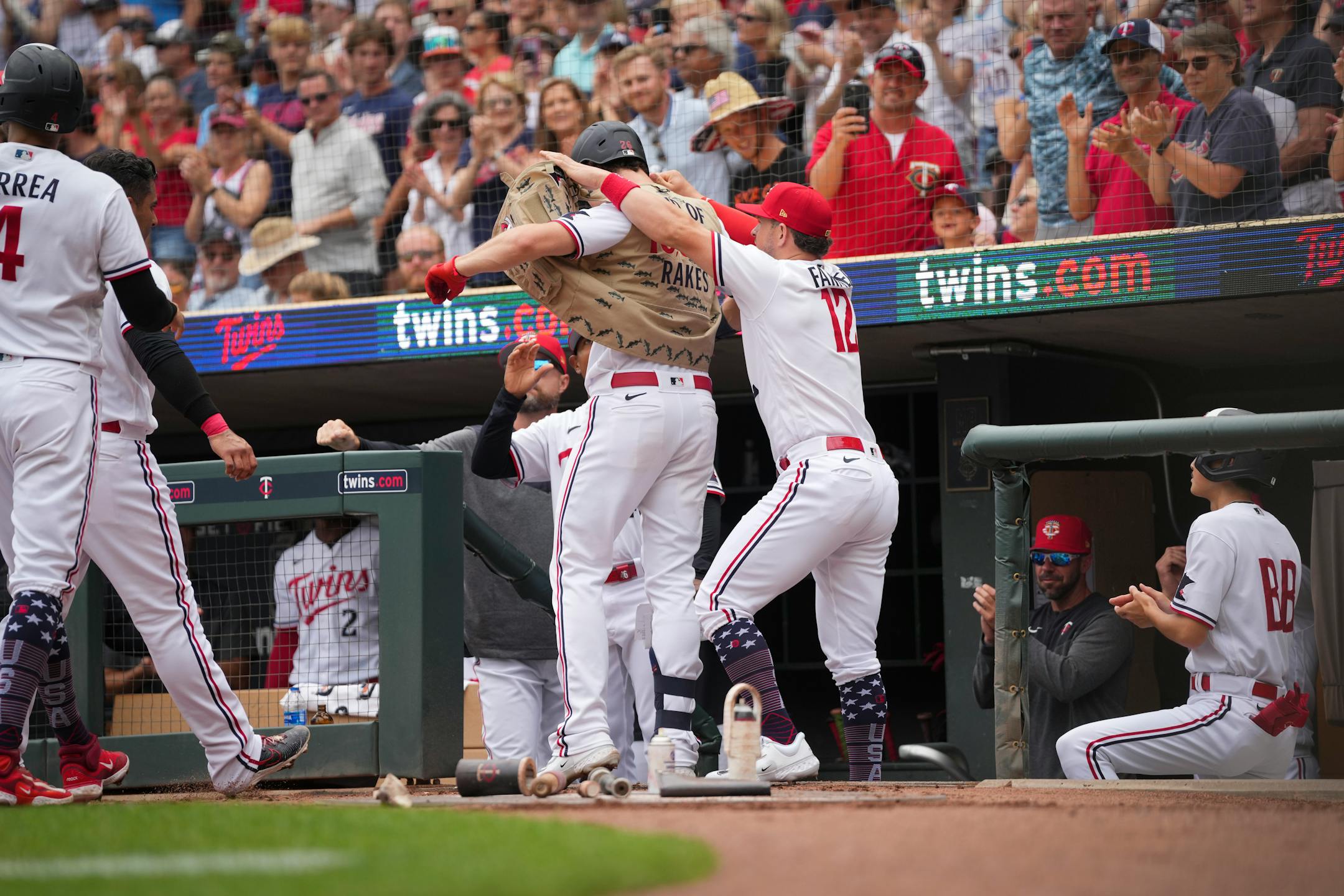 Minnesota Twins third baseman Kyle Farmer (12) puts the celebratory home run fishing vest on Minnesota Twins right fielder Max Kepler (26) who hit a three-run home run in the third inning.