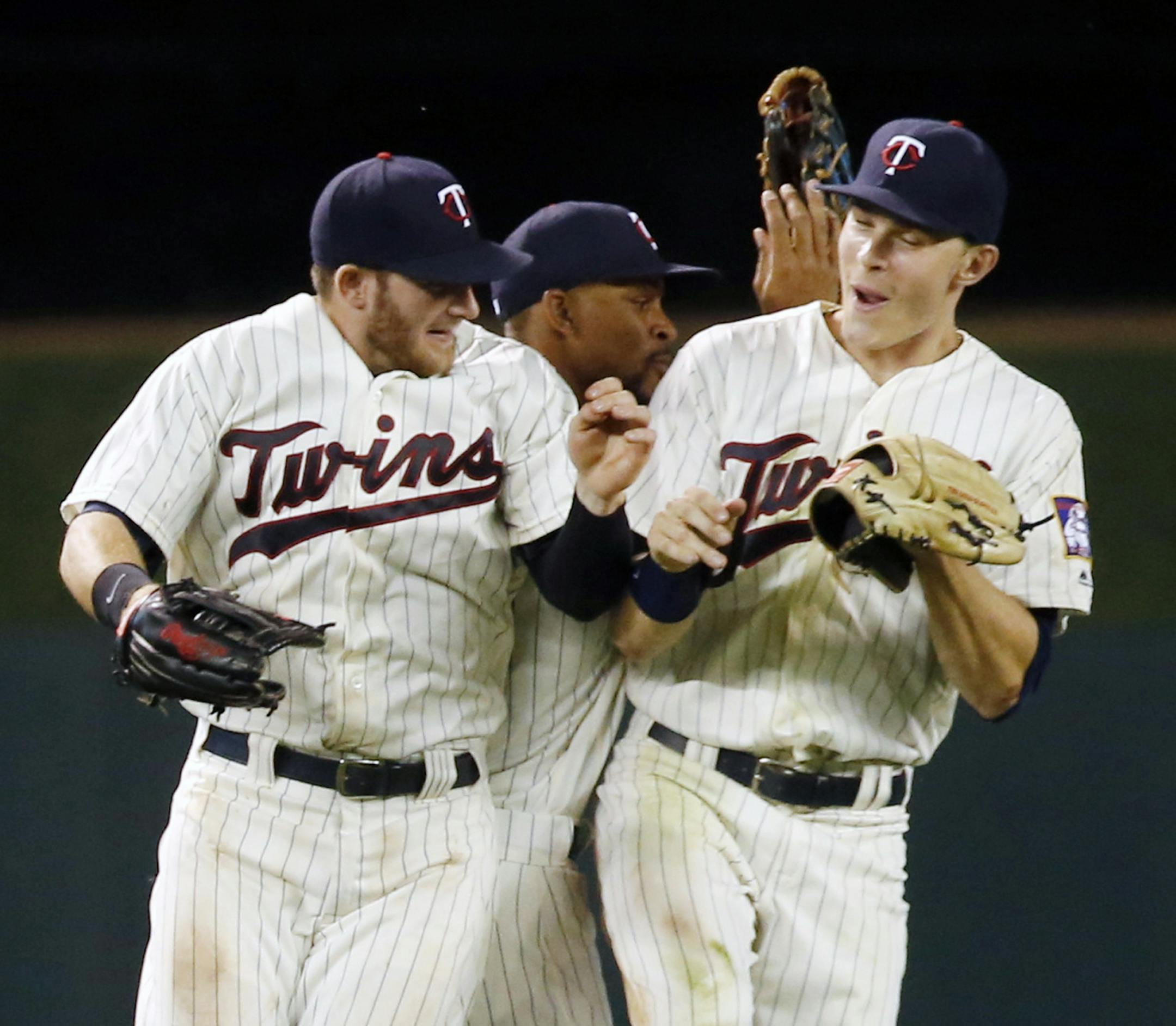 Minnesota Twins outfielders, from left, Robbie Grossman, Byron Buxton and Max Kepler celebrate after the Twins defeated the Philadelphia Phillies 6-5 in a baseball game Wednesday, June 22, 2016, in Minneapolis. (AP Photo/Jim Mone)