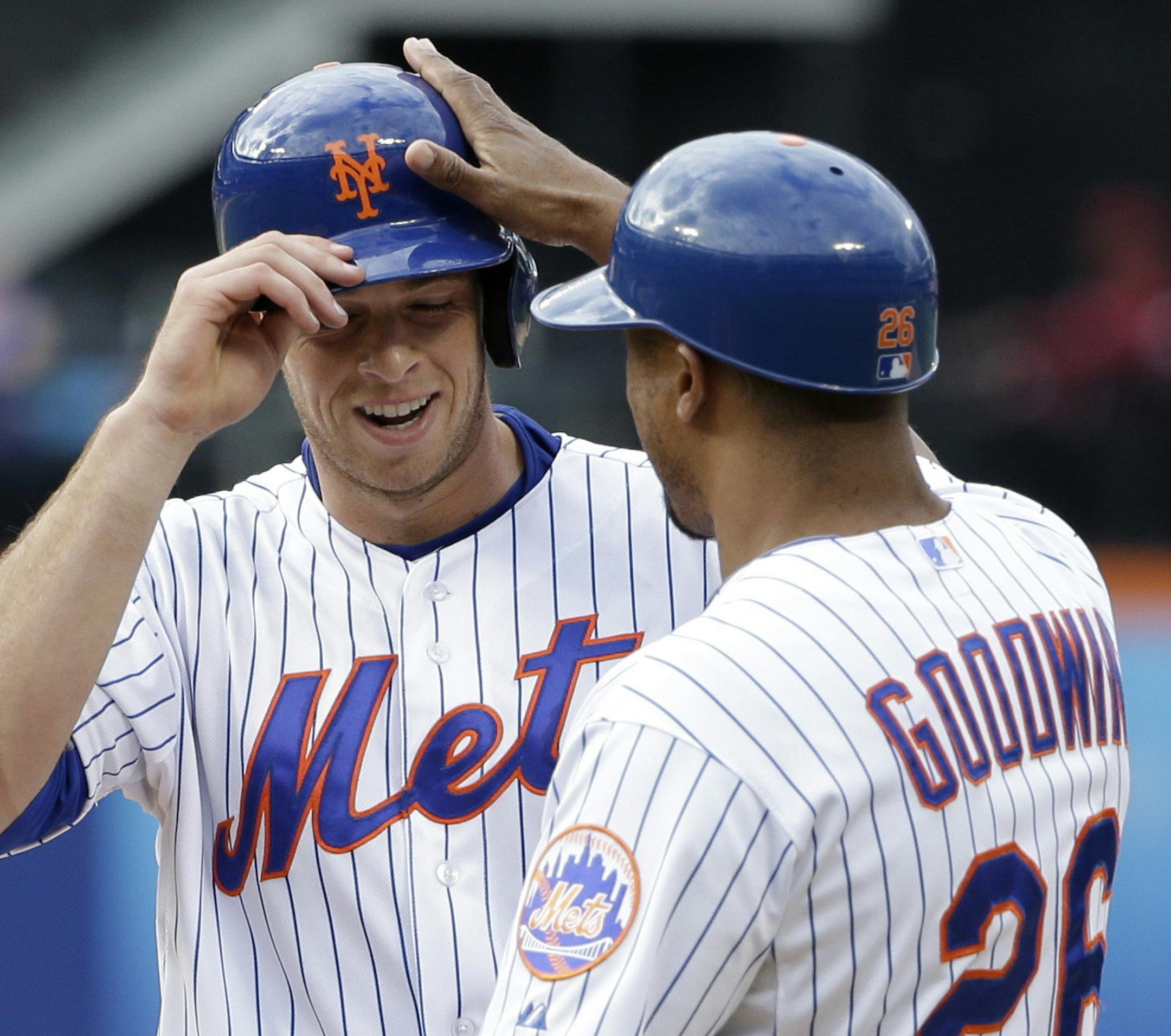 New York Mets' Steven Matz, left, is greeted by first base coach Tom Goodwin after hitting a single during the fifth inning of the baseball game against the Cincinnati Reds at Citi Field, Sunday, June 28, 2015, in New York. (AP Photo/Seth Wenig)