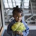 Layla Jones, 2, holds broccoli while waiting for her mother to pay for groceries.