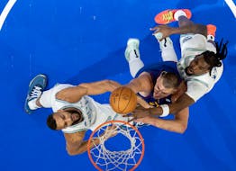 Wolves centers Naz Reid (11) and Rudy Gobert (27) keep Nuggets center Nikola Jokic sandwiched in the first half of Game 6 at Target Center on Thursday