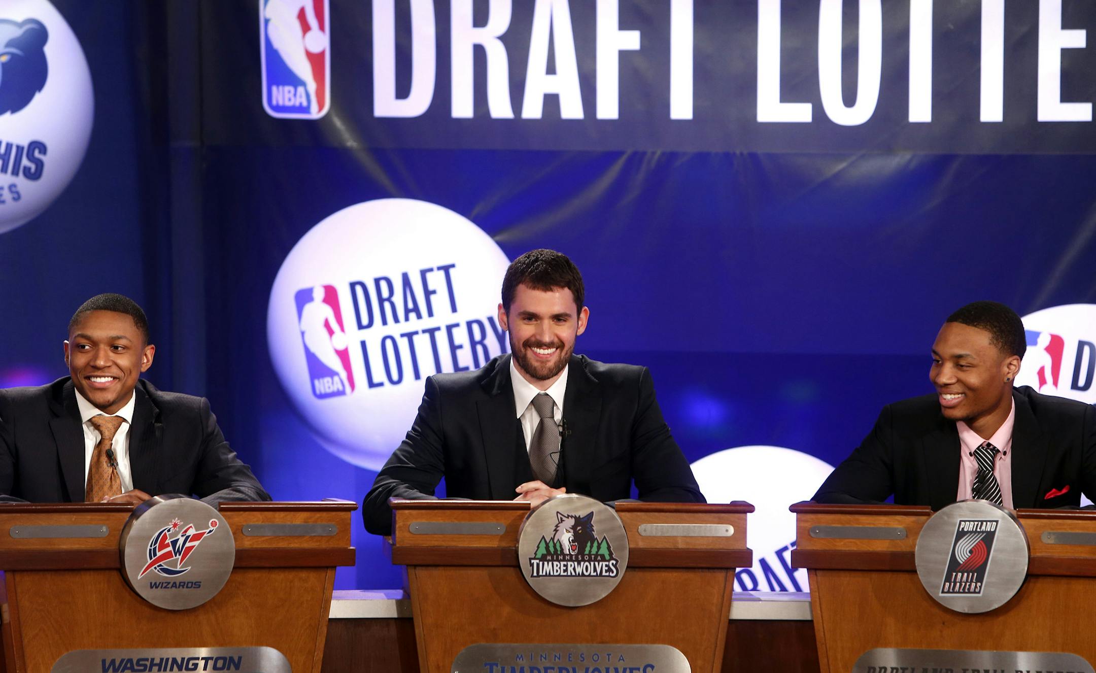 NBA basketball players, from left, Washington Wizards' Bradley Beal, Minnesota Timberwolves' Kevin Love and Portland Trailblazers' Damian Lillard represent their teams during the NBA draft lottery, Tuesday, May 21, 2013 in New York. (AP Photo/Jason DeCrow) ORG XMIT: NYJD113