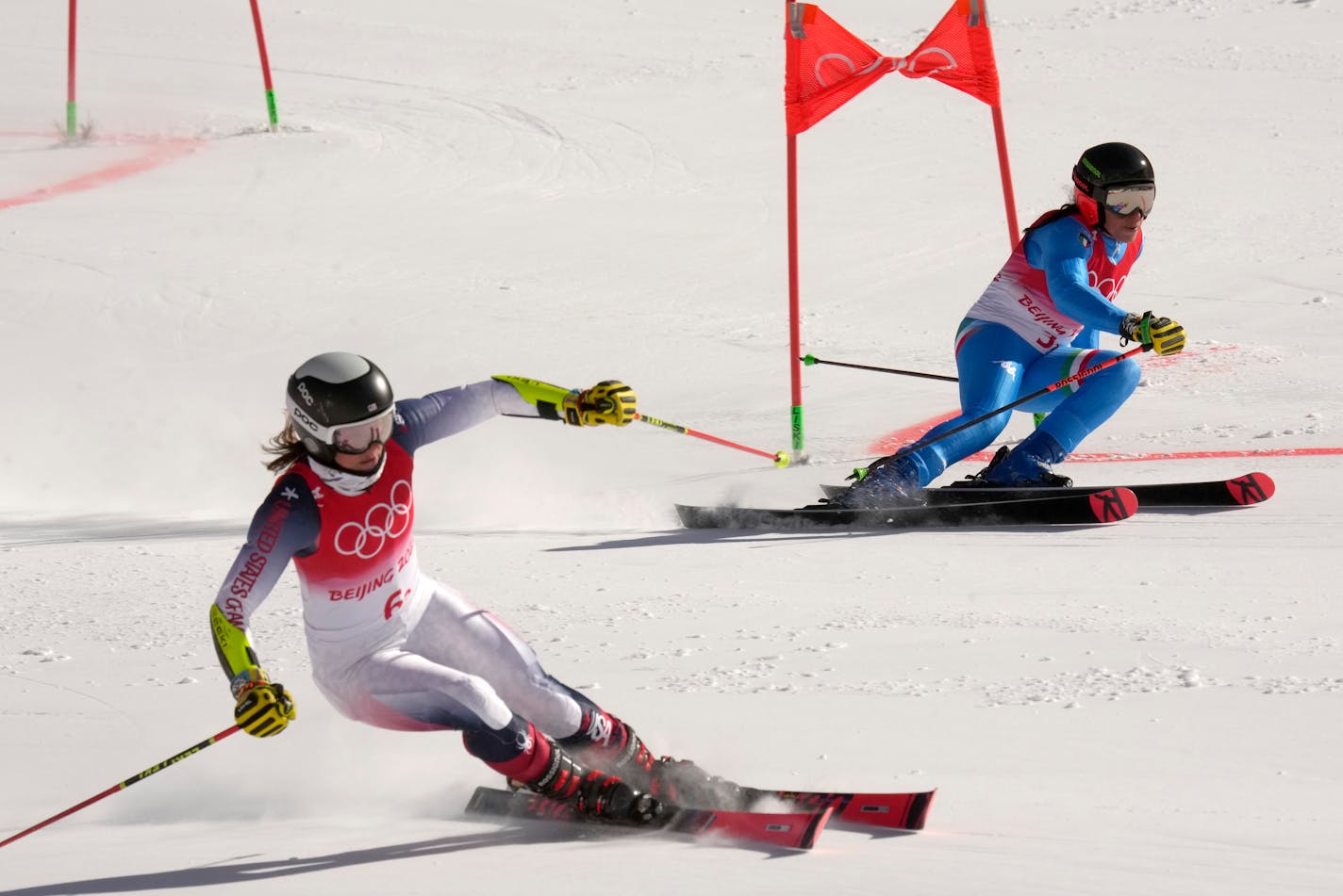 Federica Brignone of Italy, right, and Prior Lake's Paula Moltzan race during a quarterfinal of the mixed team skiing event at the 2022 Winter Olympics on Sunday in the Yanqing district of Beijing.