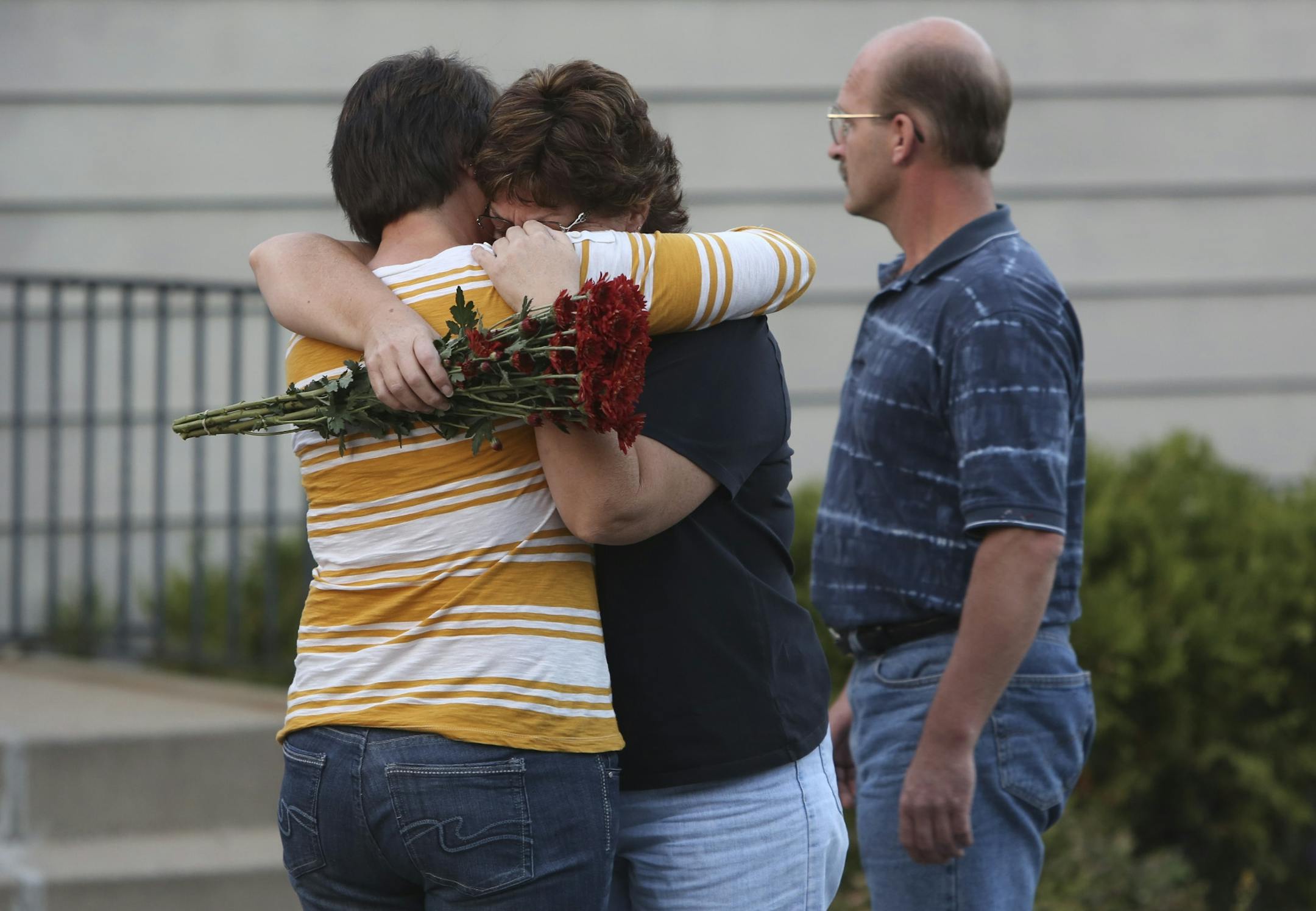 Lori Nix, sister of Ron Edberg, hugged another family member near the memorial made for the victims in front of Accent Signage Systems in Minneapolis, Min., Saturday September 29, 2012. Edberg was one of the employees that lost his life Thursday at the hands of Andrew Engeldinger.