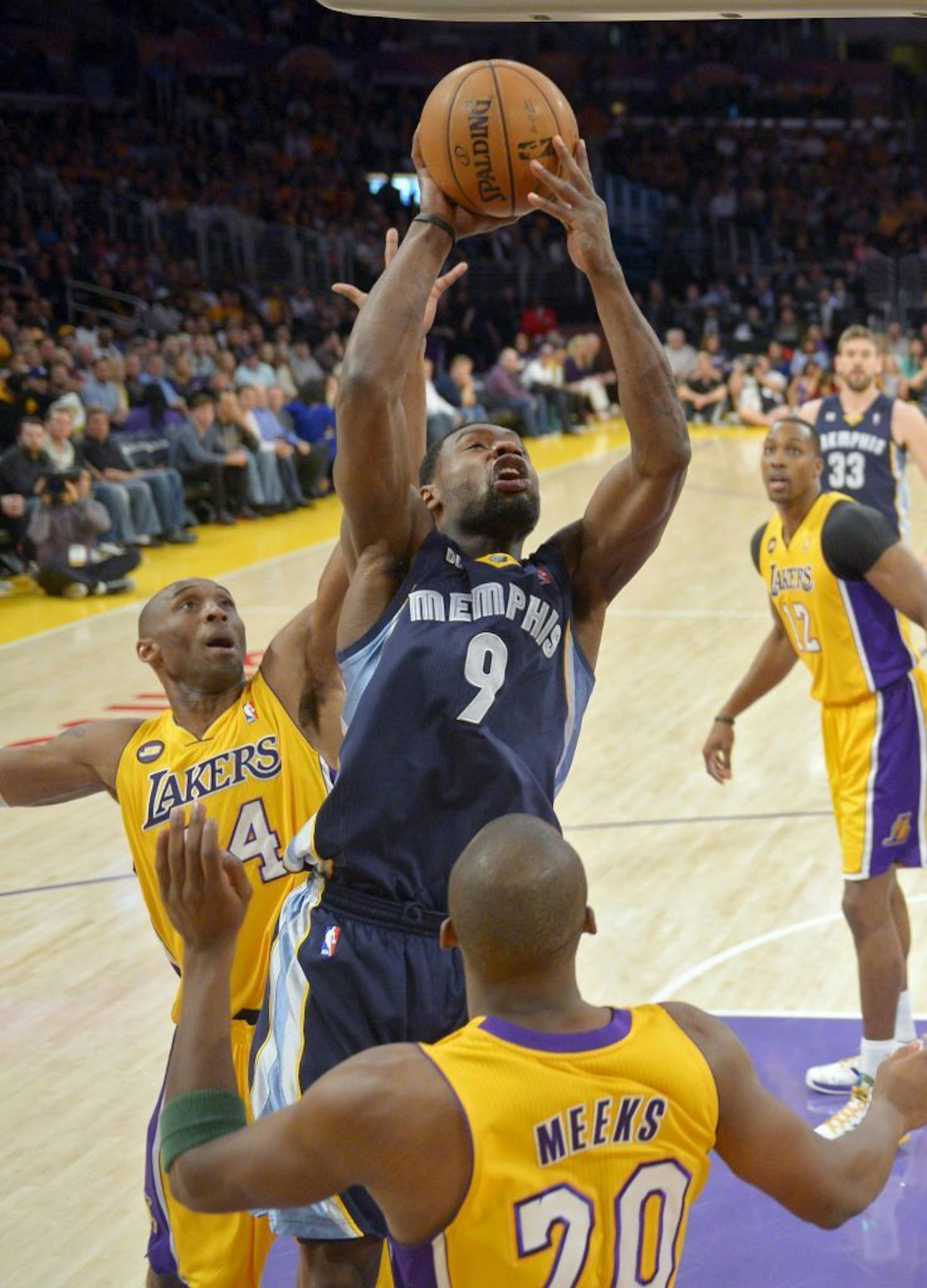 Memphis Grizzlies guard Tony Allen, center puts up a shot as Los Angeles Lakers guard Kobe Bryant, left, defends along with guard Jodie Meeks during the first half of their NBA basketball game, Friday, April 5, 2013, in Los Angeles.