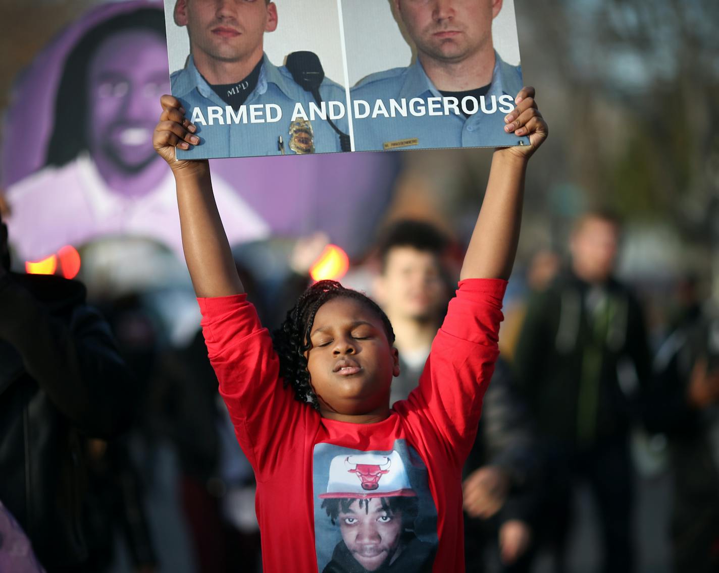 A niece of Jamar Clark protested with a photograph of the two Minneapolis Police that were involved in Clark&#xed;s death. Family members, friends and activists marched too the spot where Jamar Clark was killed in a confrontation with city police last fall to commemorate his death Tuesday October 15, 2016 in Minneapolis, MN.] Jerry Holt / jerry. Holt@Startribune.com