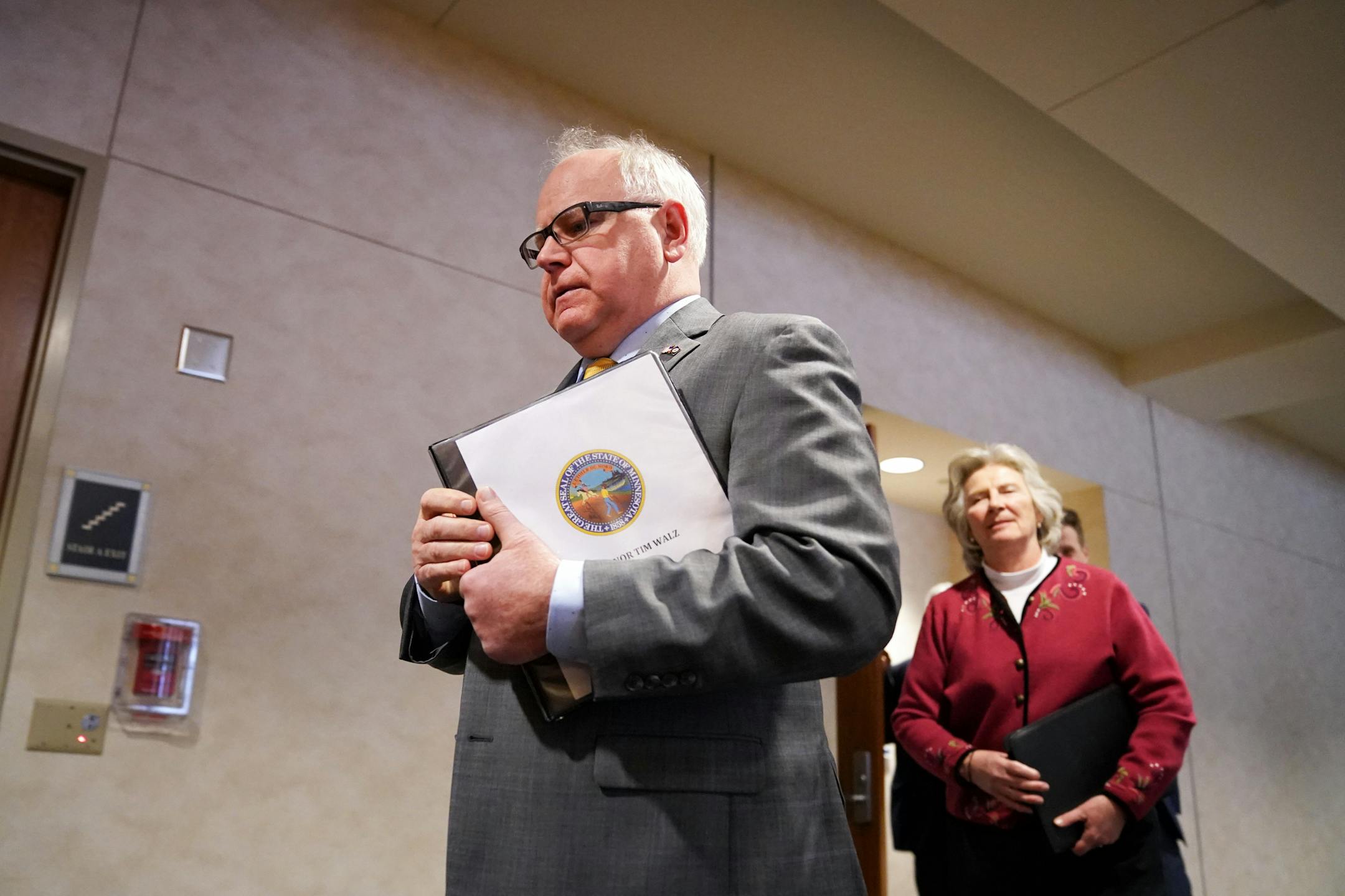 Gov. Tim Walz walked into a news conference late Monday afternoon at which he announced that all restaurants and bars in the state should be limited to delivery and takeout service starting Tuesday. With him is Minnesota Health Commissioner Jan Malcolm,