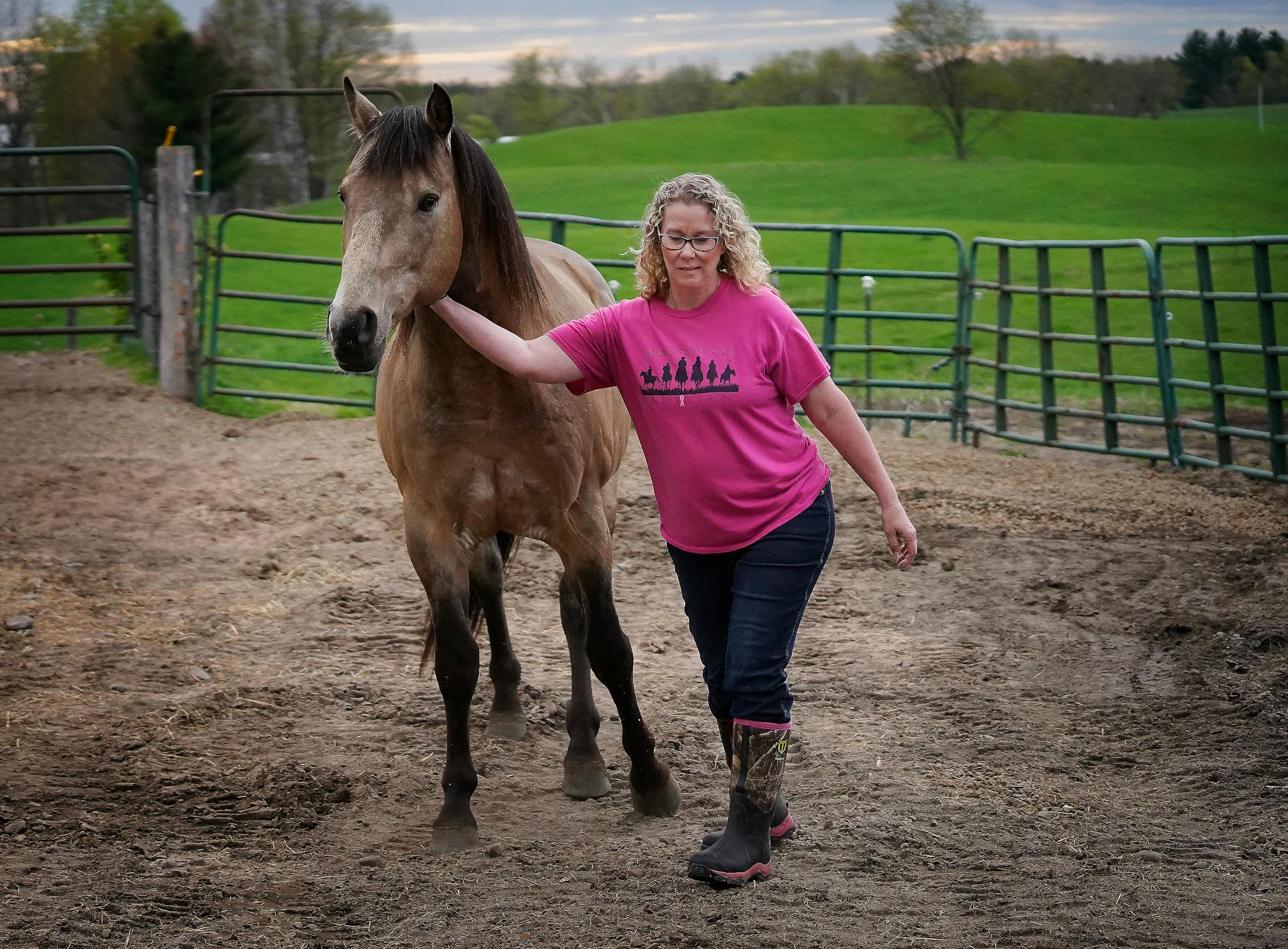 Animal Human Society agent Amanda Oquist, escorts stallion Cisco back to his enclosure after he had snuck out while Oquist did morning chores before heading to work Wednesday, May 18, 2022, near Finlayson, Minn.