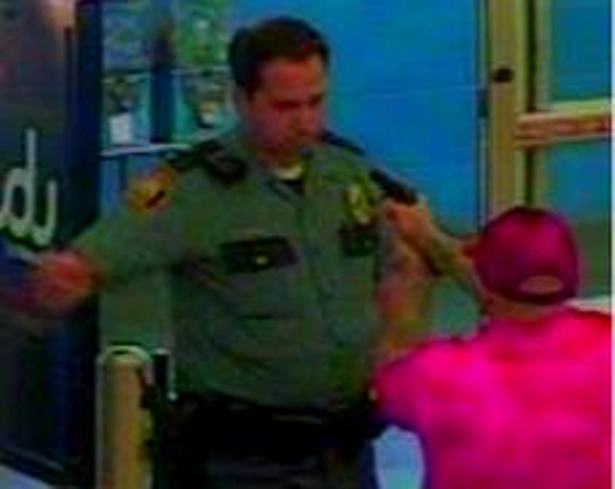 A man suspected of shoplifting points a gun at an off-duty officer at a St. Paul Wal-Mart in this surveillance image.