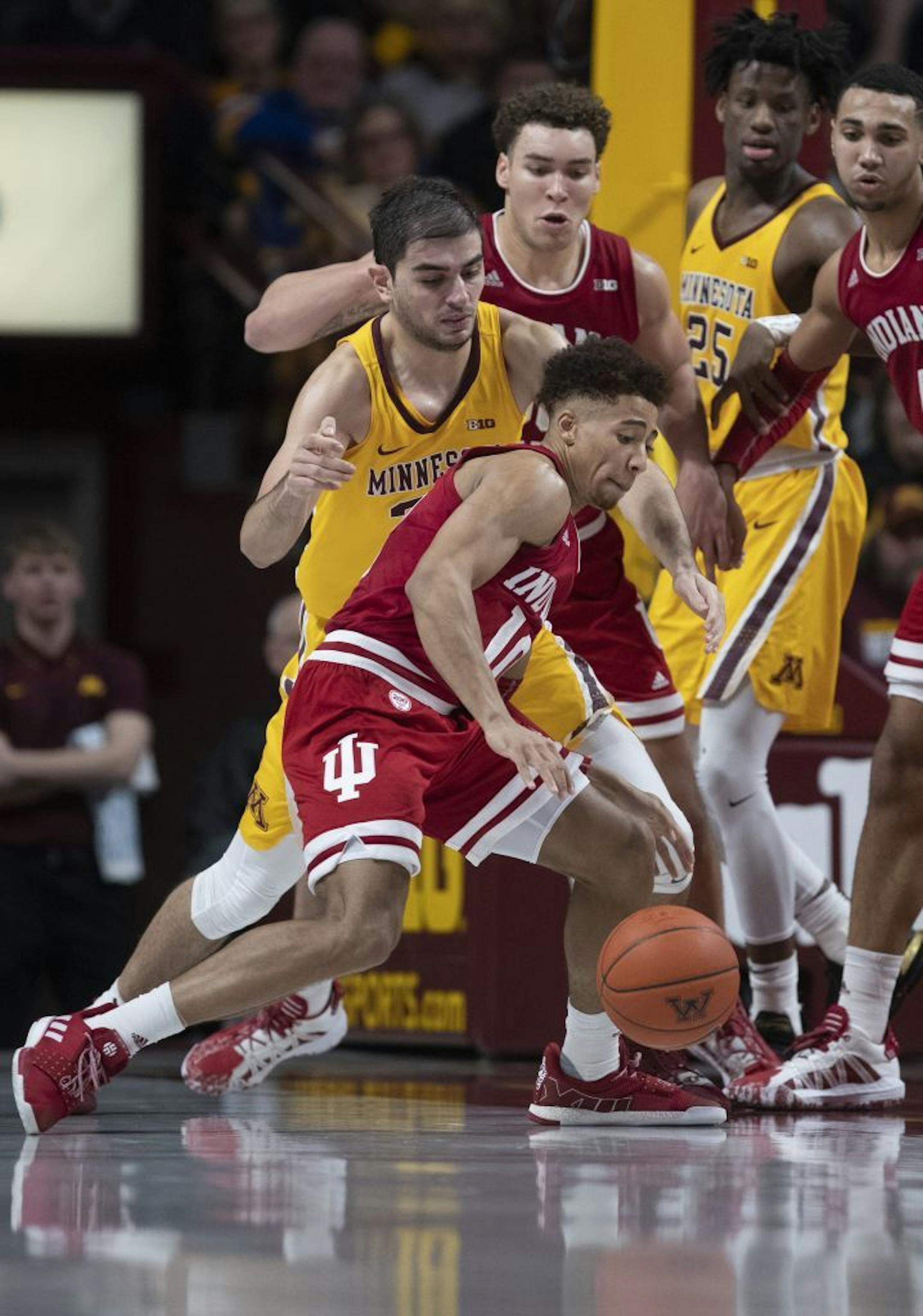 Indiana Hoosiers guard Rob Phinisee (10) stole the ball from Minnesota Gophers forward Alihan Demir (30) late in the second half .