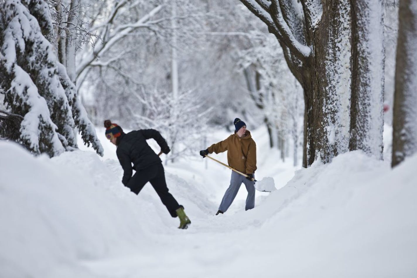 Neighbors Andrea Page and Peter Jorgensen were two of several neighbors clearing the sidewalk of their Minneapolis neighborhood which had still yet to be plowed the morning after 10.5 inches of snow fell in the Minneapolis, Minn., on Friday, February 22, 2014.