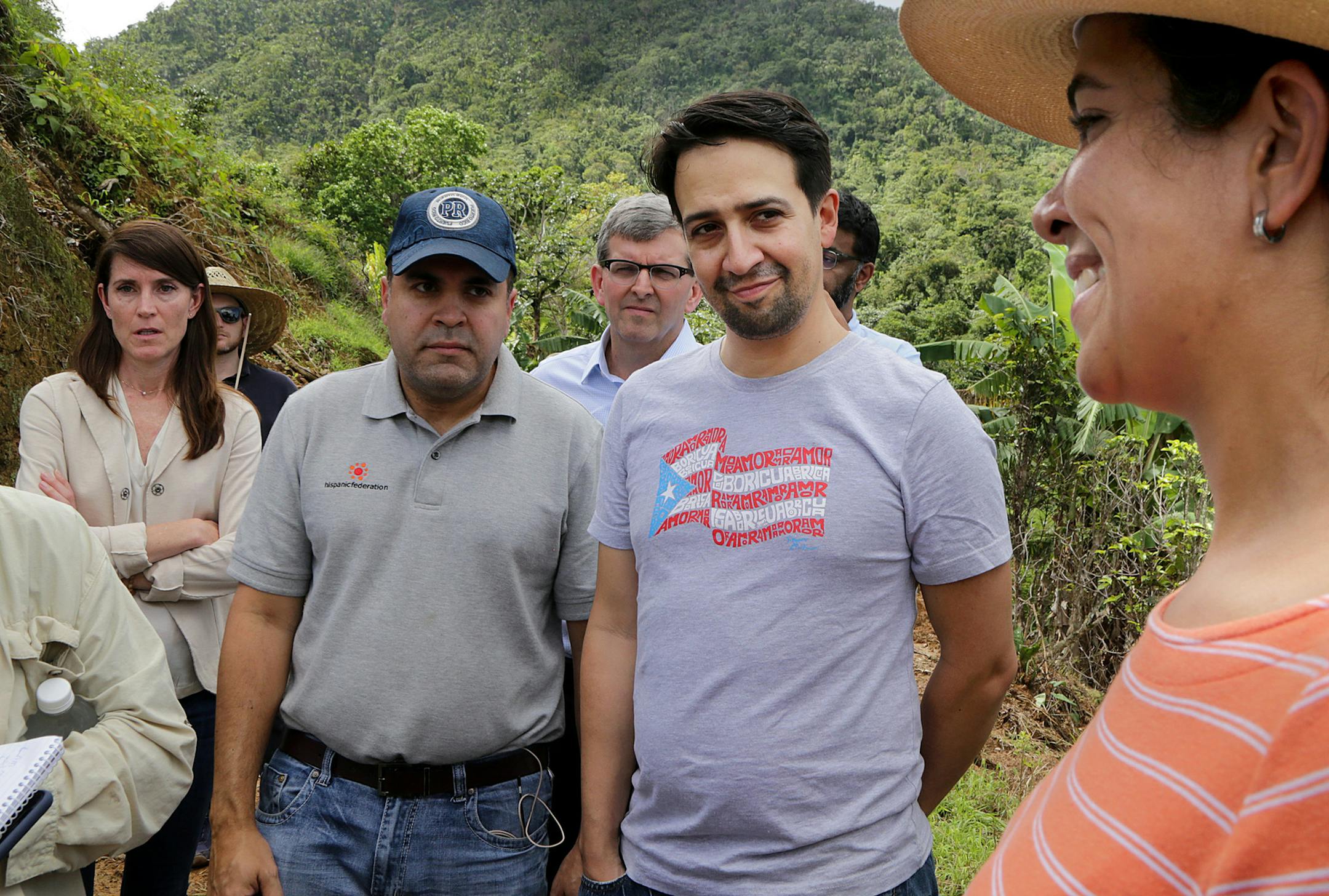 Coffee farmer Vanessa Arroyo, Lin-Manuel Miranda, midle, and Jose Calderon, left, President of the Hispanic Federation, react during a walking tour in Jayuya, where they made an announcement related to supporting the island's coffee industry on October 24, 2018. (Pedro Portal/Miami Herald/TNS)