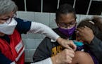 Nurse practitioner Judy Kuczenski gives a kid does of the Pfizer vaccine to Sephira Dragseth,6, as her mother Toya Dragseth holds her in St. Paul, Min