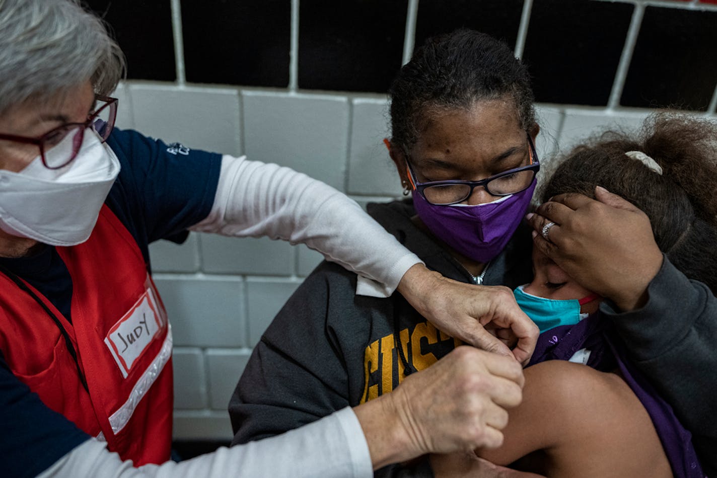 Nurse practitioner Judy Kuczenski gives a kid does of the Pfizer vaccine to Sephira Dragseth,6, as her mother Toya Dragseth holds her in St. Paul, Minn., on Monday, Nov. 15, 2021 at Como Park Elementary School. The St. Paul Public Schools (SPPS) district is kicking off its COVID-19 vaccine campaign Monday for students ages 5-11. ] RICHARD TSONG-TAATARII • richard.tsong-taatarii@startribune.com