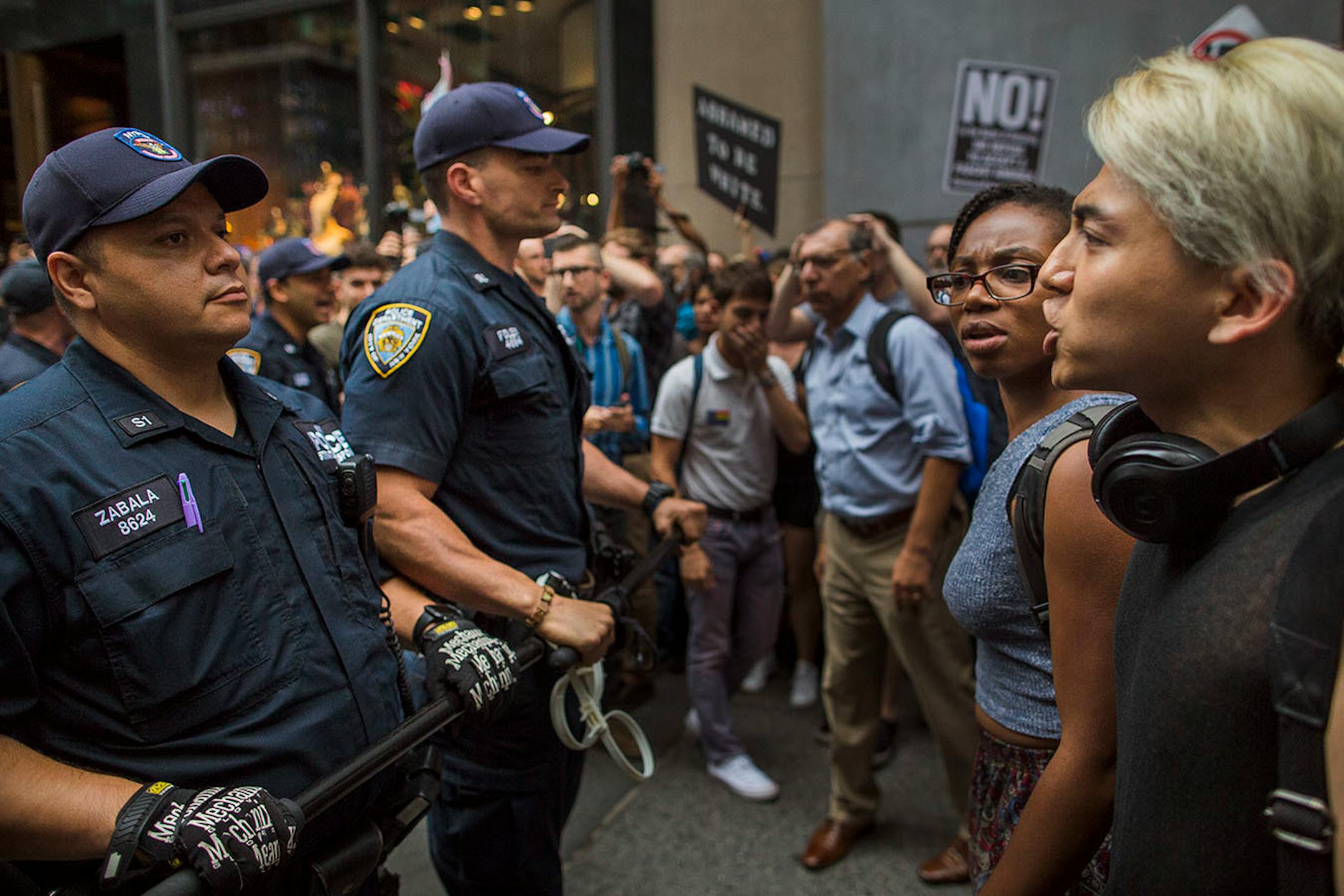 Protestors shout to the police in front of Trump Tower ahead President Donald Trump's first visit to the building since taking office, New York, Monday, Aug. 14, 2017. (