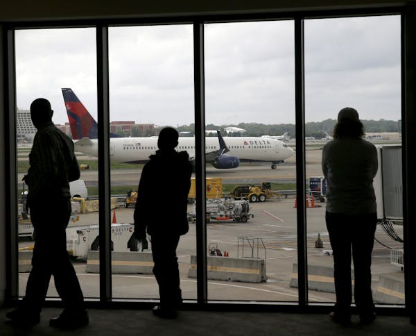 FILE - In this April 14, 2015, file photo, Delta Air Lines passengers watch as a Delta plane taxis at Atlanta's Hartsfield International Airport in At