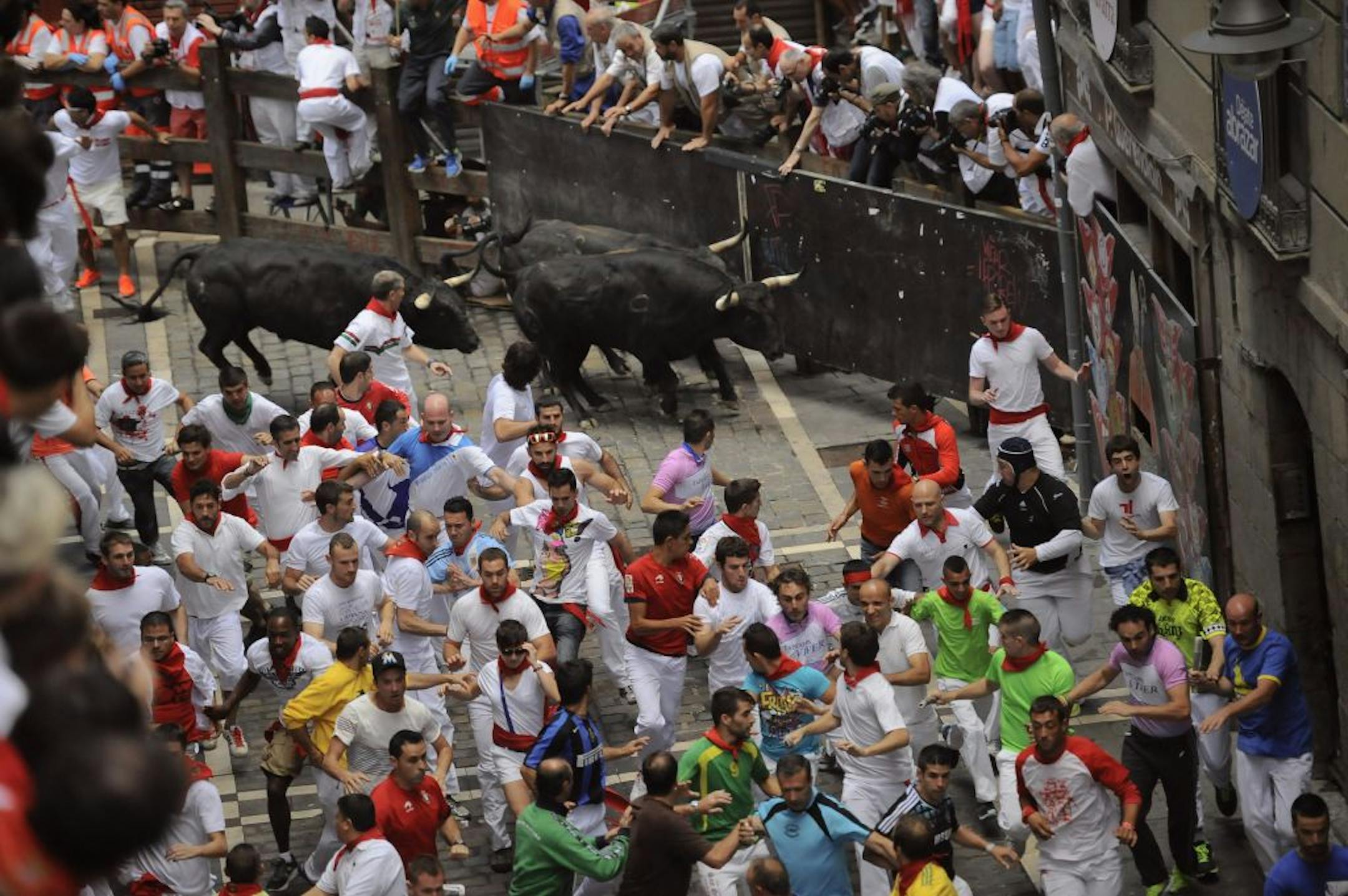 A "Fuente Ymbror" fighting bull runs behind revelers during the running of the bulls at the San Fermin festival, in Pamplona, Spain, Saturday, July 13, 2013. Revelers from around the world arrive in Pamplona every year to take part in some of the eight days of the running of the bulls glorified by Ernest Hemingway's 1926 novel "The Sun Also Rises."