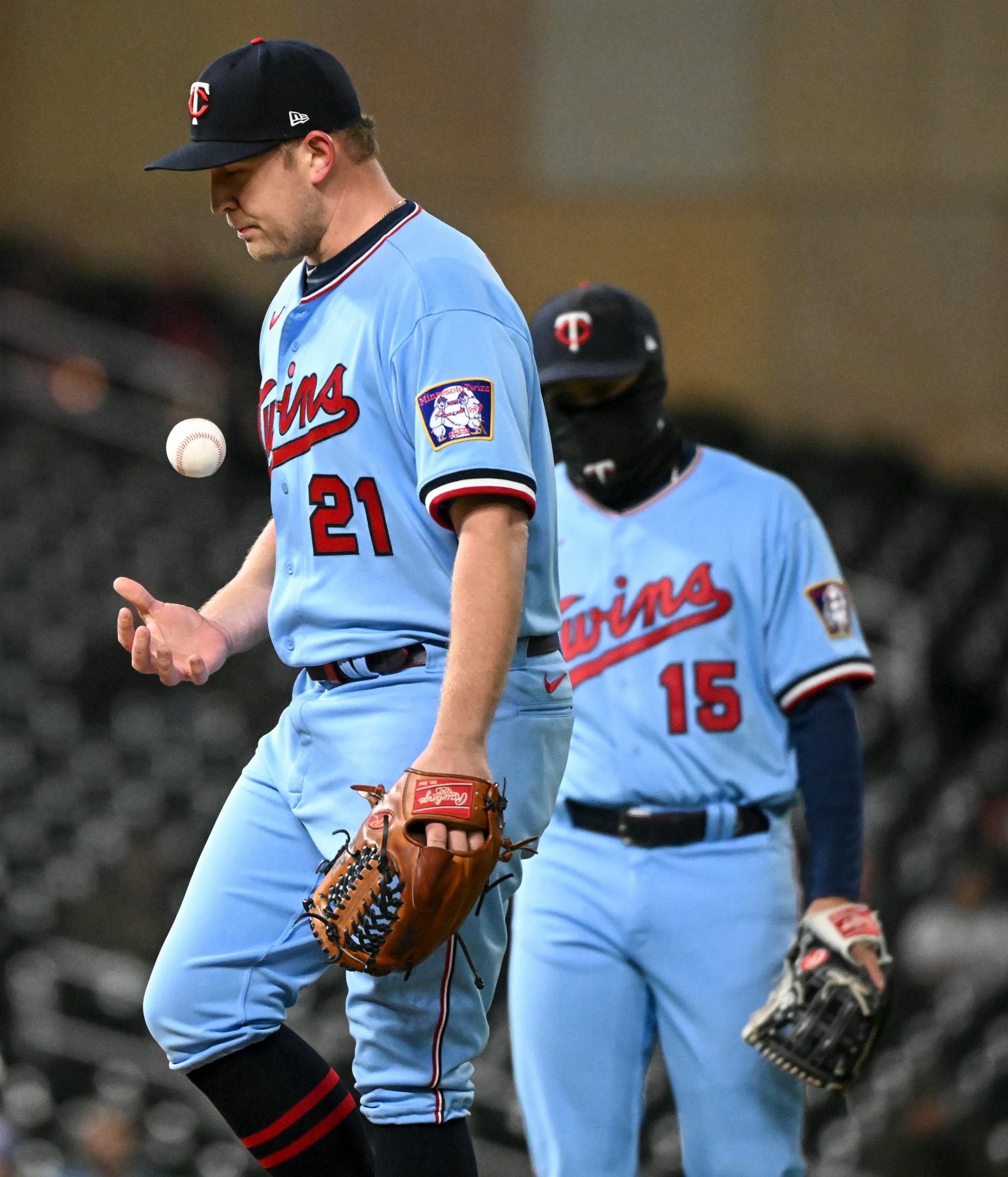 Minnesota Twins relief pitcher Tyler Duffey (21) tosses the ball as manager Rocco Baldelli (5) approaches the mound before a pitching change in the top of the seventh inning.