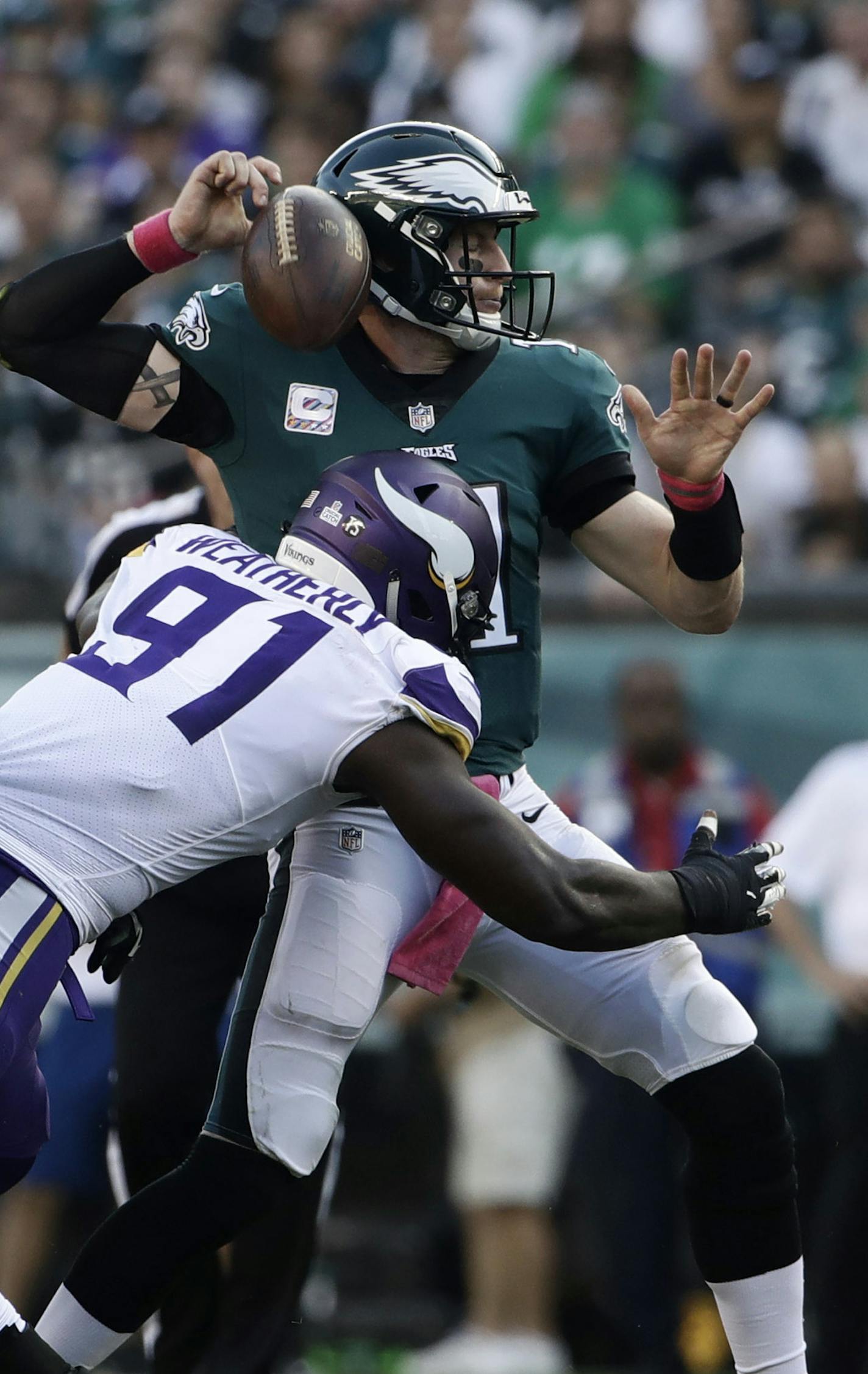 Philadelphia Eagles' Carson Wentz, right, fumbles after a hit from Minnesota Vikings' Stephen Weatherly (91) during the first half of an NFL football game, Sunday, Oct. 7, 2018, in Philadelphia. (AP Photo/Matt Rourke)