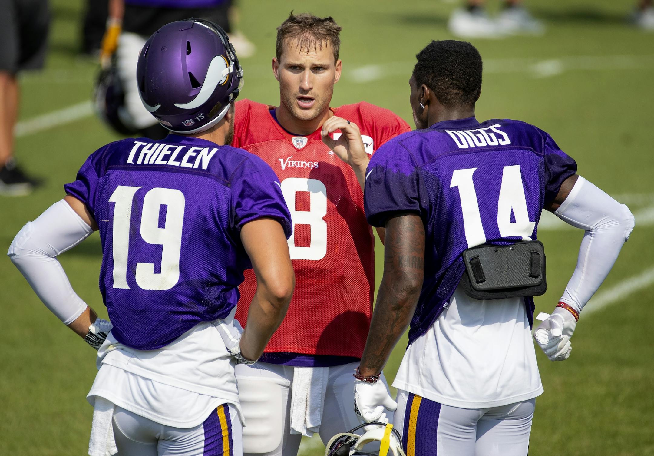 Minnesota Vikings quarterback Kirk Cousins spoke with receivers Adam Thielen (19) and Stefon Diggs (14) during a joint practice with the Jacksonville Jaguars.