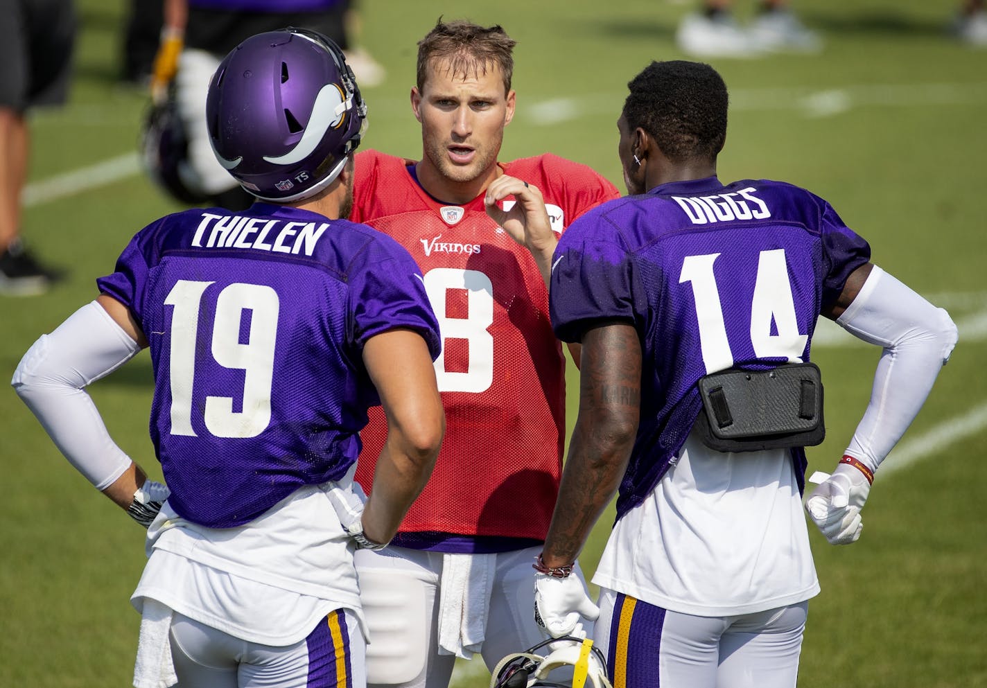 Minnesota Vikings quarterback Kirk Cousins spoke with receivers Adam Thielen (19) and Stefon Diggs (14) during a joint practice with the Jacksonville Jaguars.