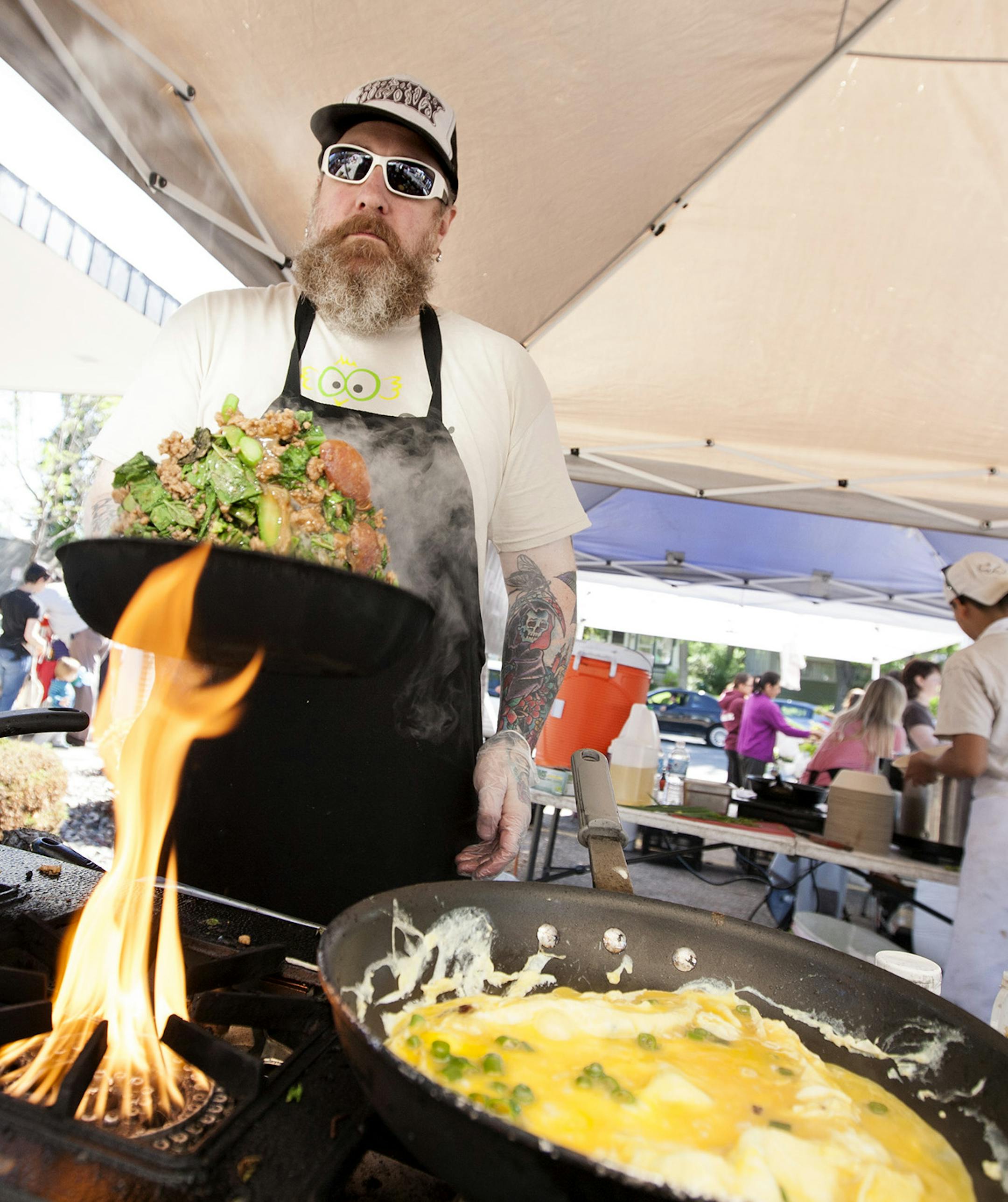 Cook David Anderson works the stove at Gai Gai Thai at the Kingfield Farmers Market June 8, 2014. (Courtney Perry/Special to the Star Tribune)