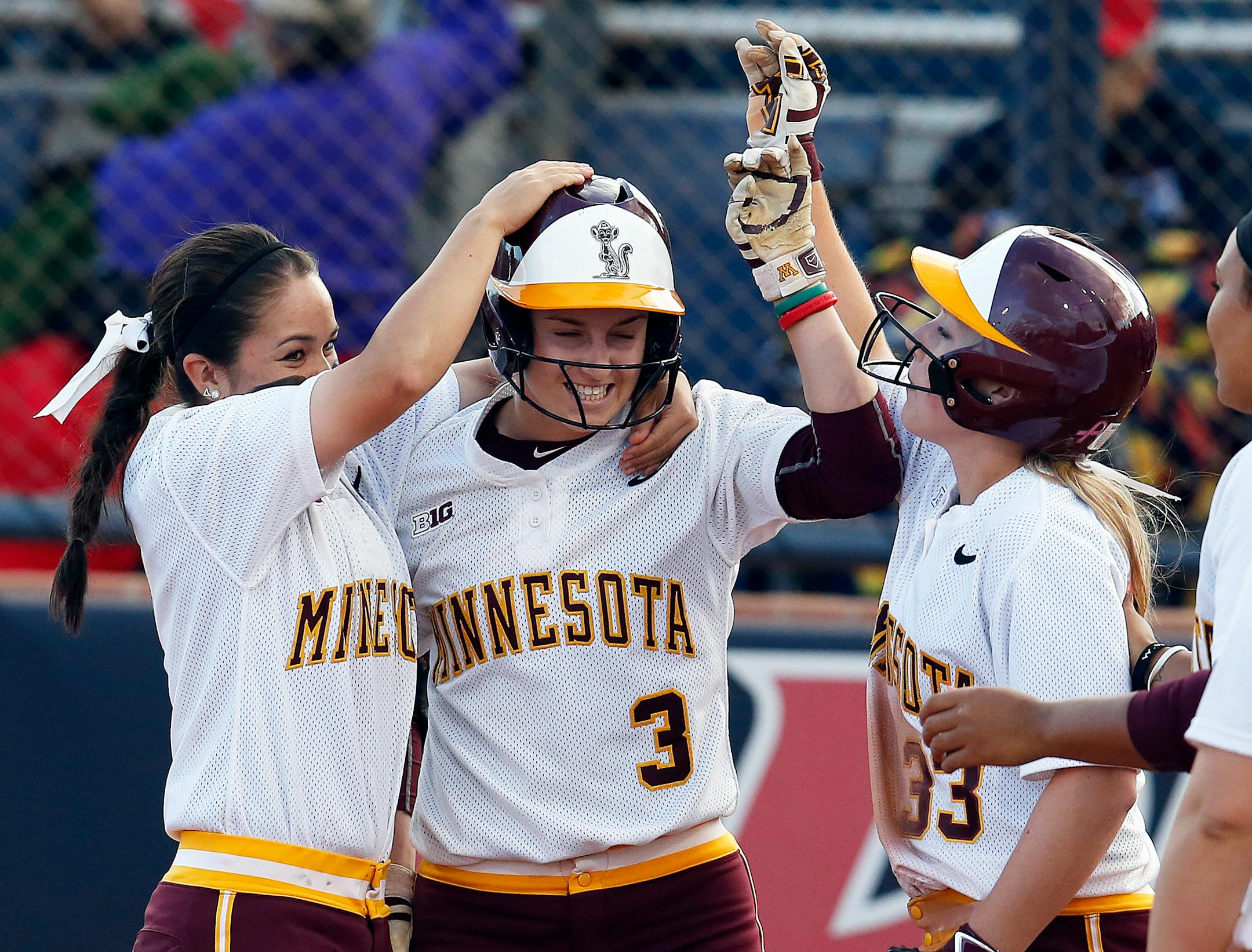 Minnesota's Erica Meyer (3) celebrates with teammates Erika Smyth (6) and Ellie Cowger (33) after defeating New Mexico State in a Division I NCAA college softball game, Friday, May 15, 2015, in Tucson, Ariz. (AP Photo/Rick Scuteri)