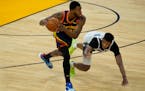 Golden State Warriors forward Andrew Wiggins, left, grabs the ball in front of Minnesota Timberwolves guard Jarrett Culver during the first half of an