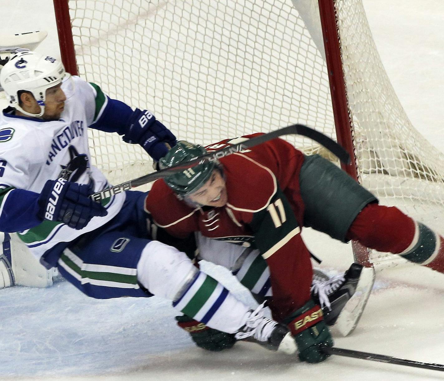 The Vancouver Canucks' Jannik Hansen (36) clears the Minnesota Wild's Zach Parise away from goalie Eddie Lack, left, at the Xcel Energy Center in St. Paul, Minn., on Wednesday, March 26, 2014. Vancouver won, 5-2. (Marlin Levison/Minneapolis Star Tribune/MCT) ORG XMIT: 1150913